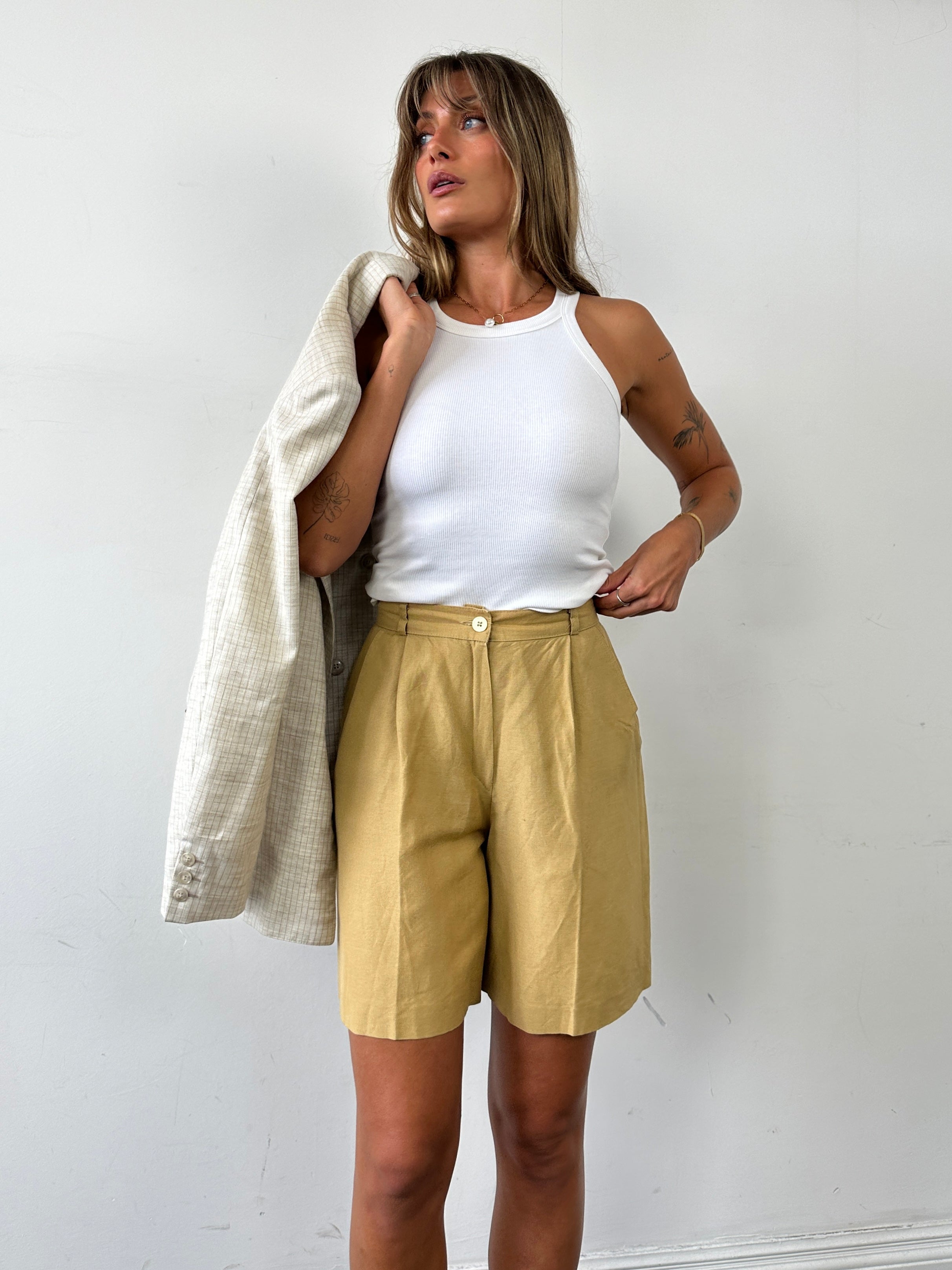 Vintage linen pleated wide-leg shorts in natural color, showing their relaxed fit and stylish design on a neutral background.