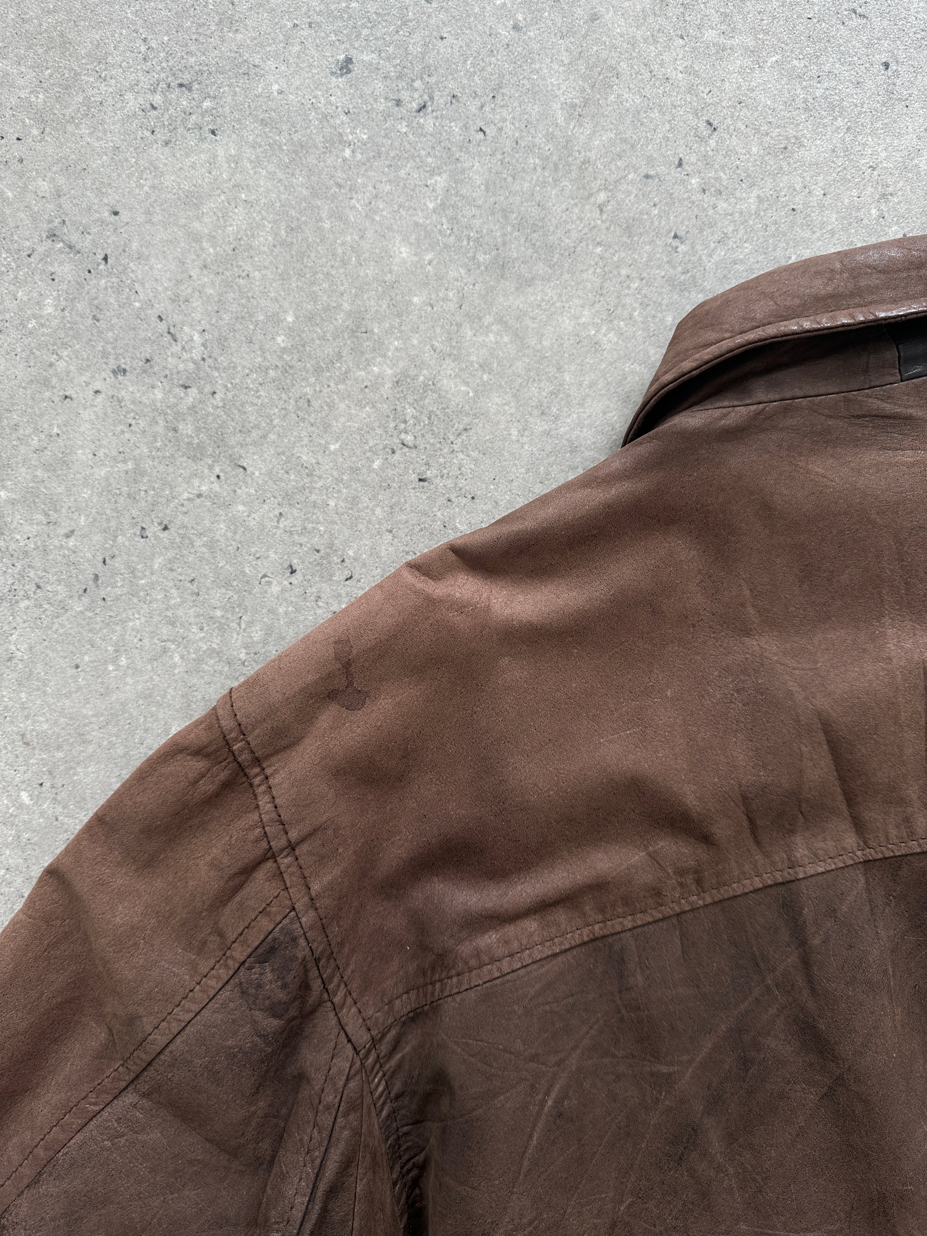 Vintage distressed leather bomber jacket in size large, featuring a rugged, worn-in look with classic style and metal zipper details.