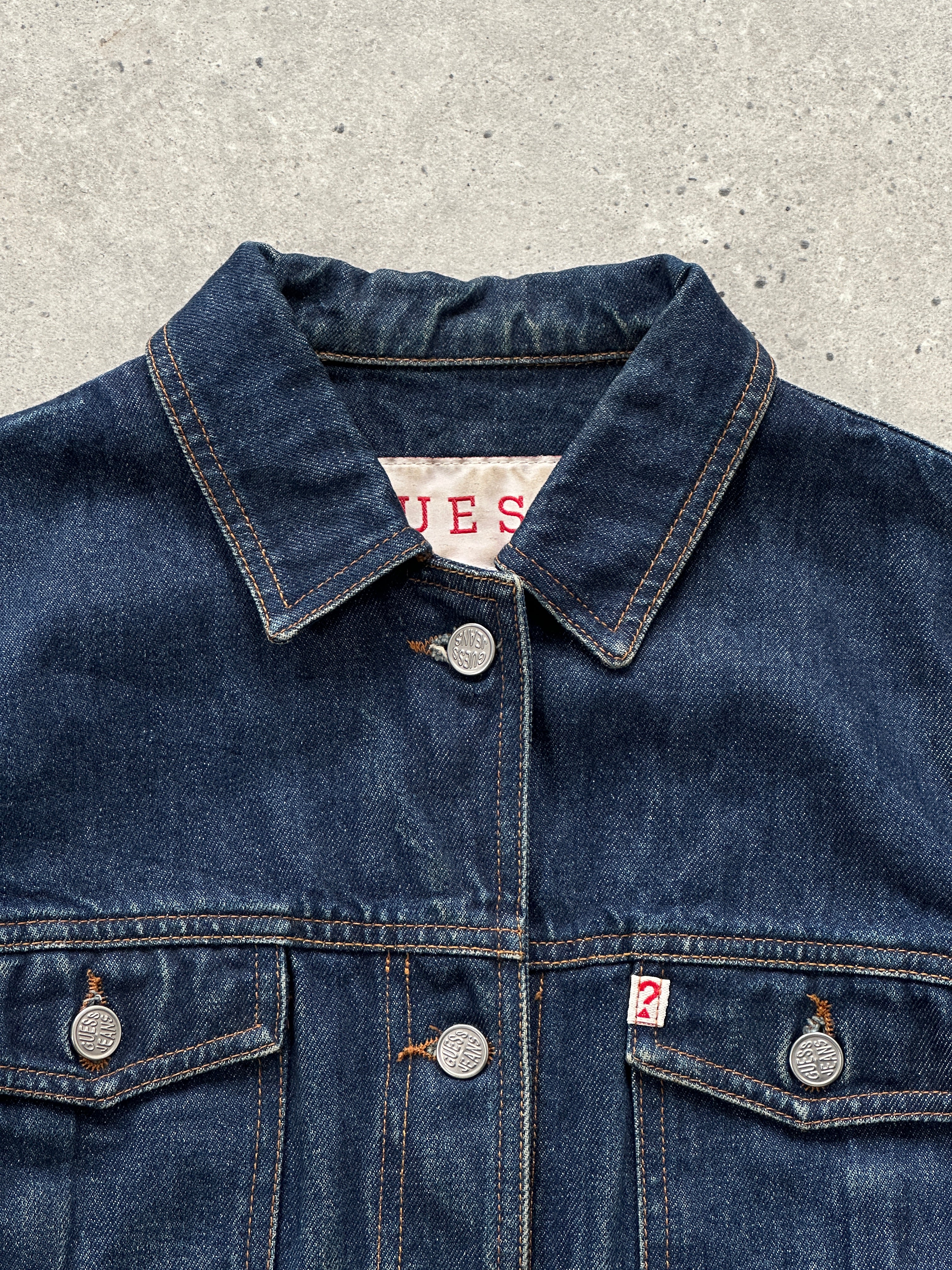 Guess contrast stitch denim jacket in size S/M, showcasing classic blue denim with stylish contrast stitching and button front.