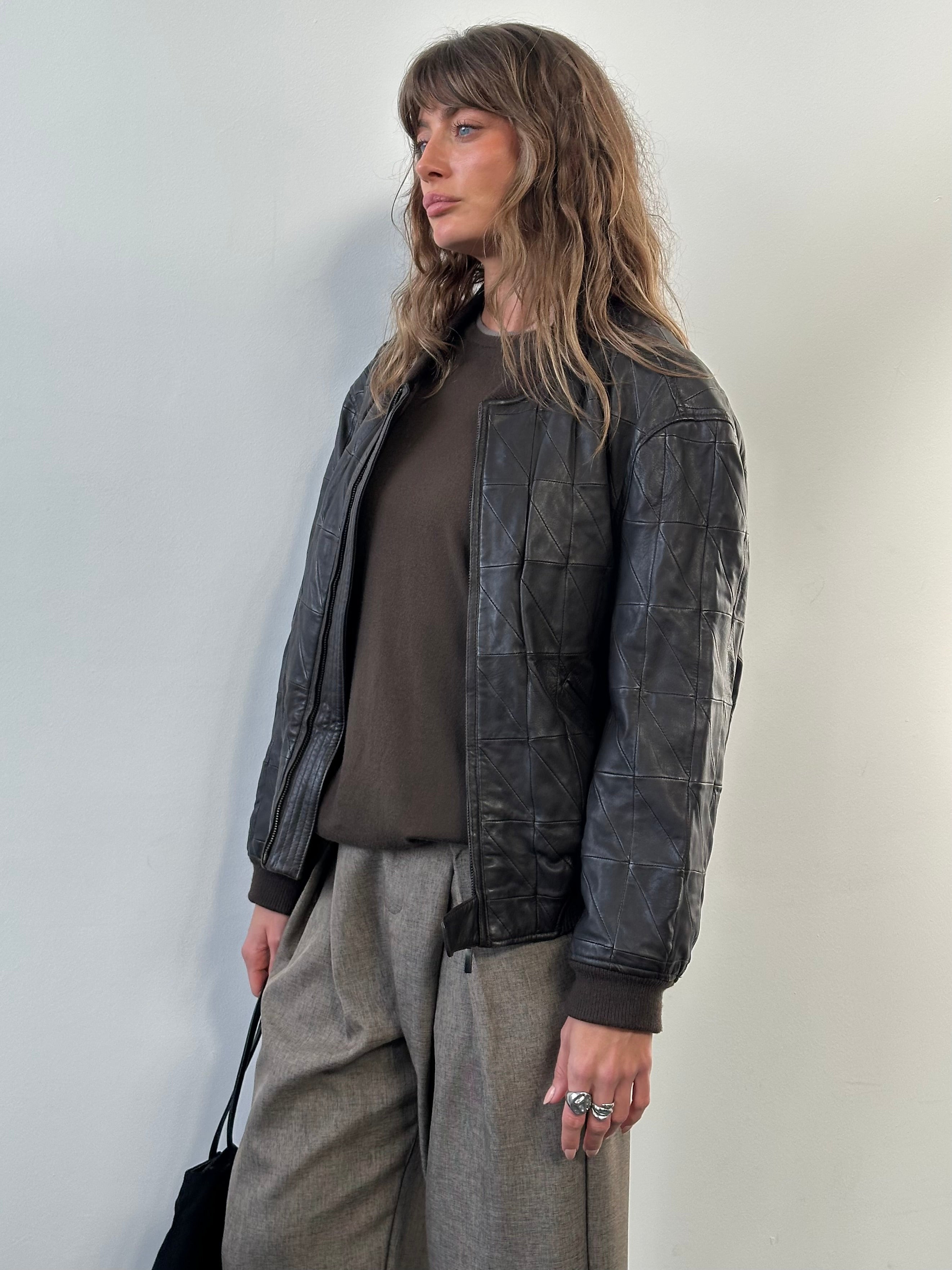 Armani Collezioni leather bomber jacket in black, 2000s style, with ribbed cuffs and collar, size S/M, displayed on a hanger.
