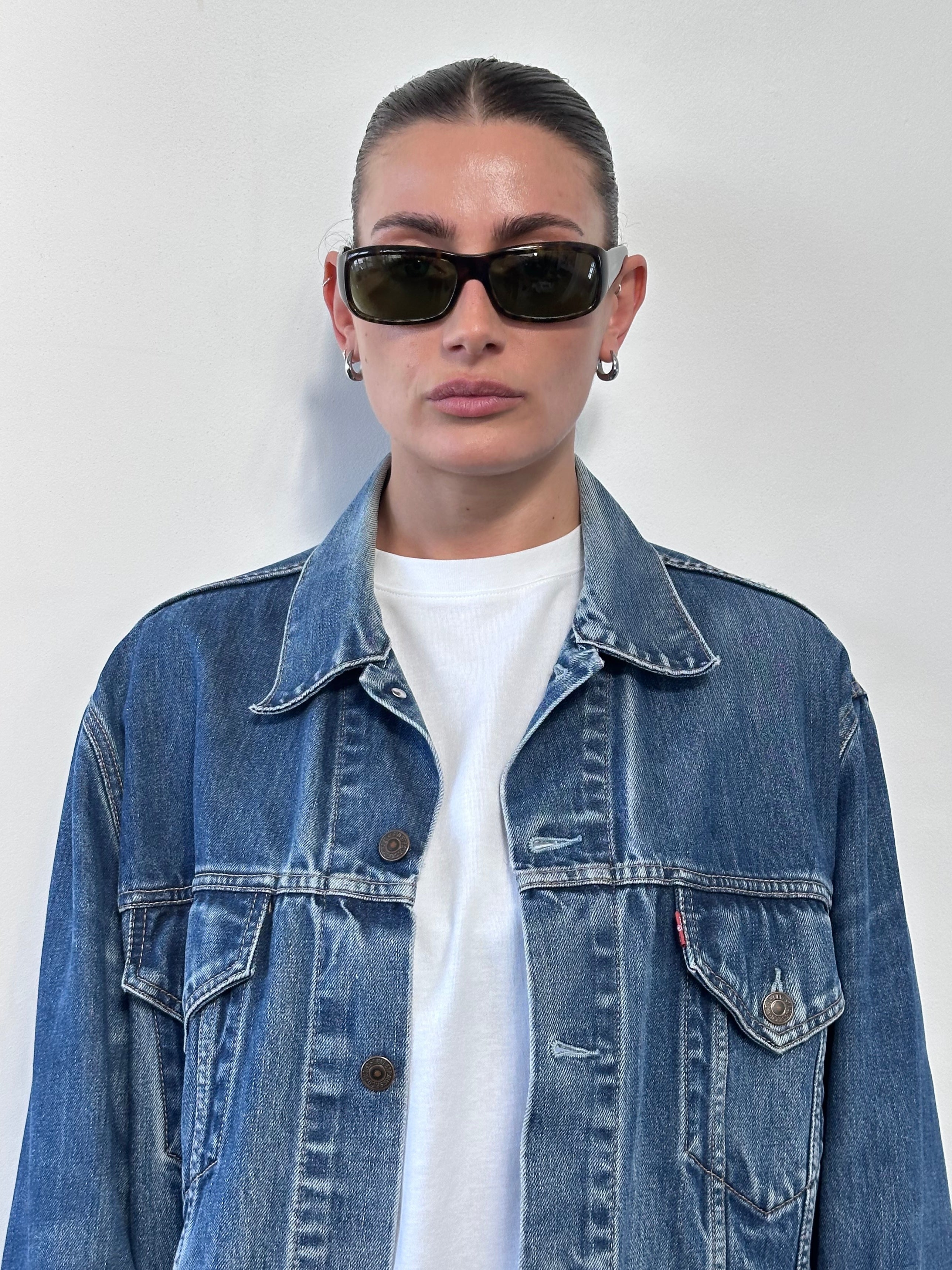 Levi’s faded denim jacket in size L showing classic distressed denim with button front and chest pockets.