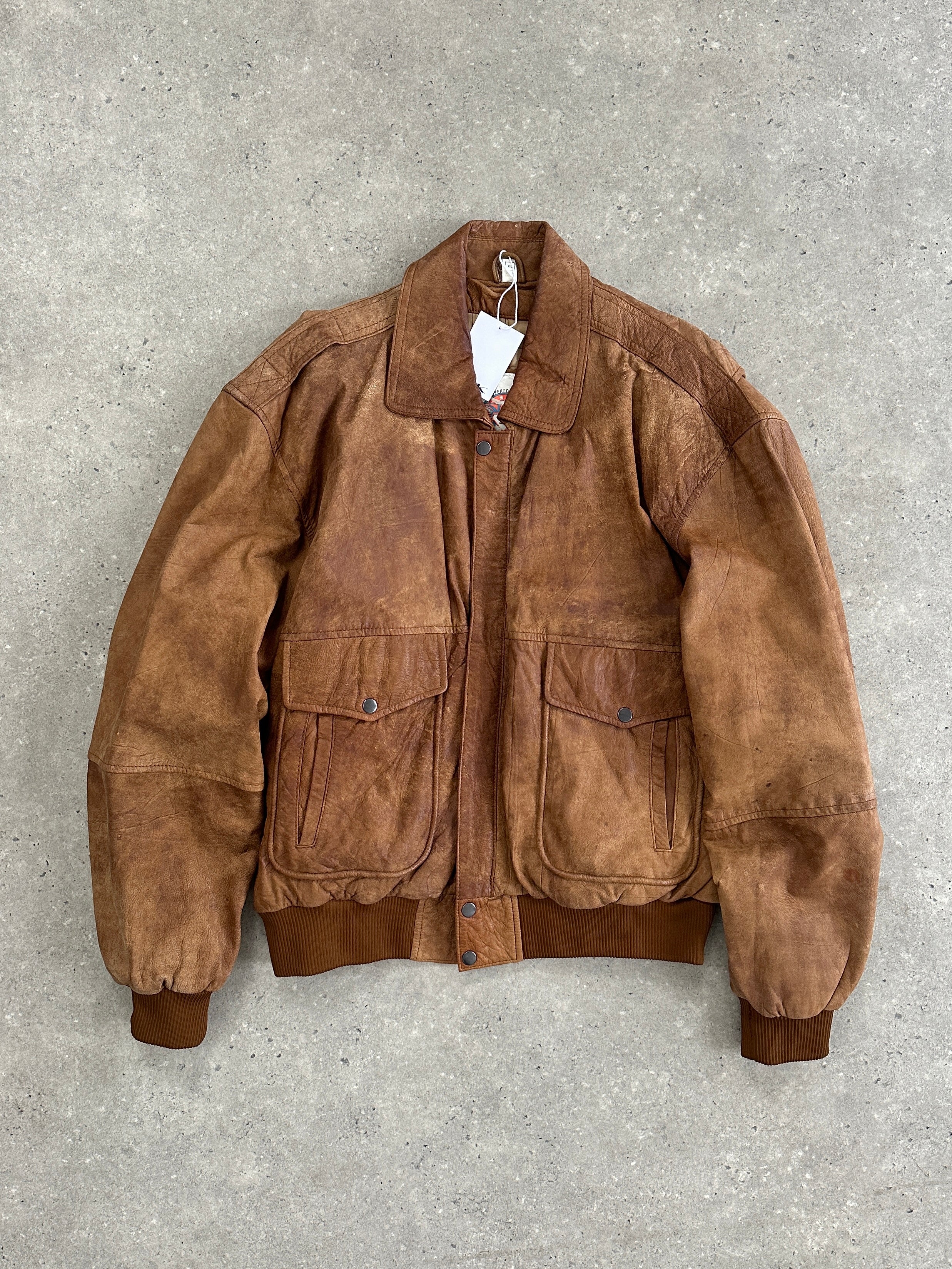 Vintage aged leather bomber jacket in XL size, featuring a classic design with distressed leather and a zip-up front.