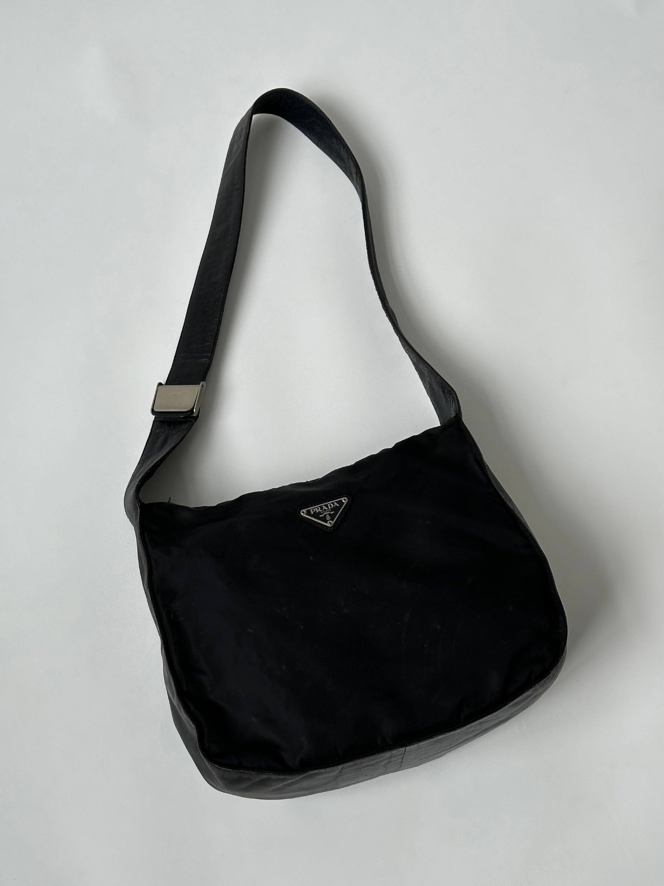 Prada nylon and leather crossbody bag with adjustable strap and sleek design, perfect for everyday use.