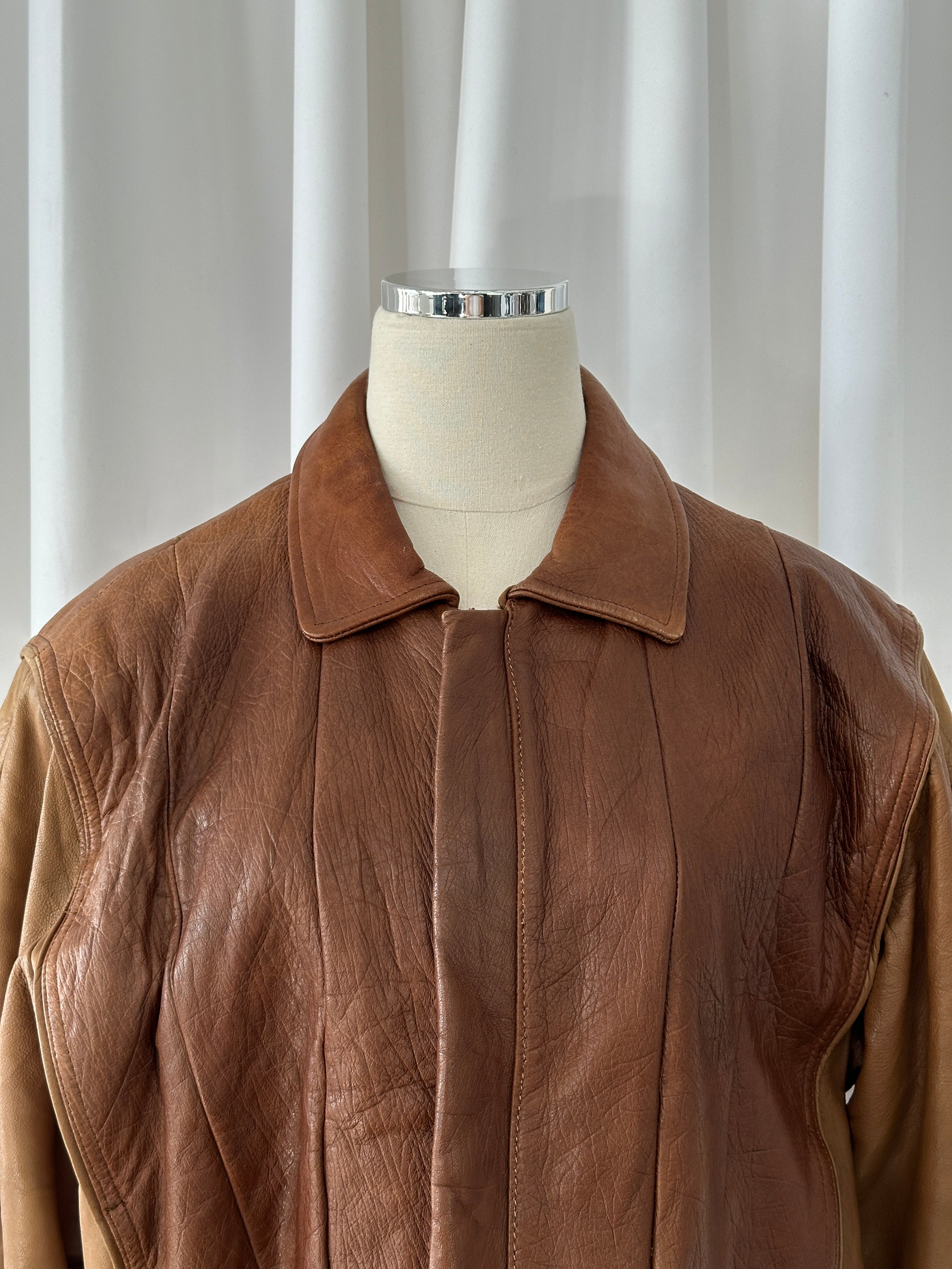 Vintage Italian 1980s leather bomber jacket with classic design, worn leather texture, and ribbed cuffs in size M/L.