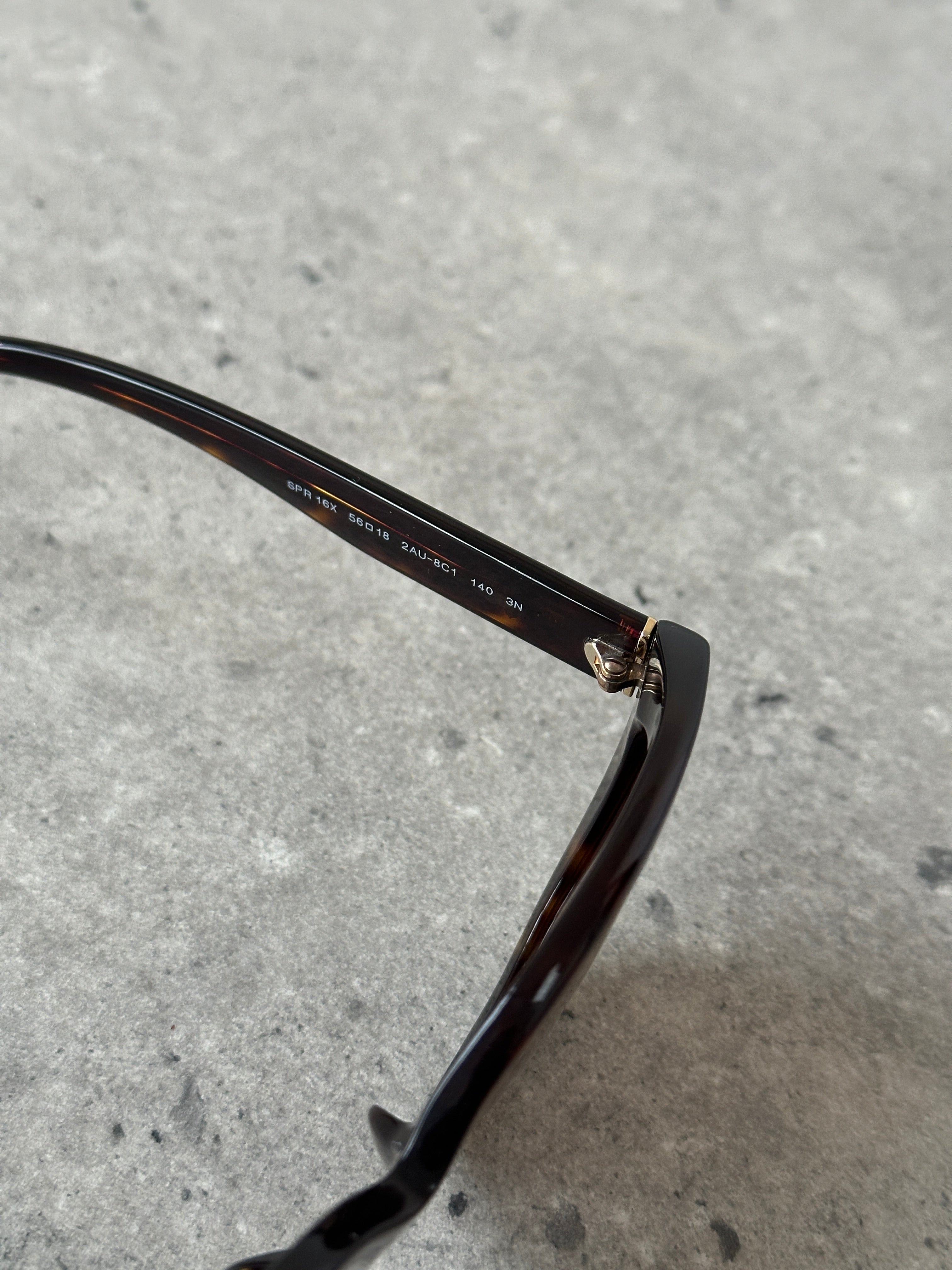 Prada tortoise shell round logo sunglasses with dark lenses and durable frame, stylish and classic eyewear accessory.
