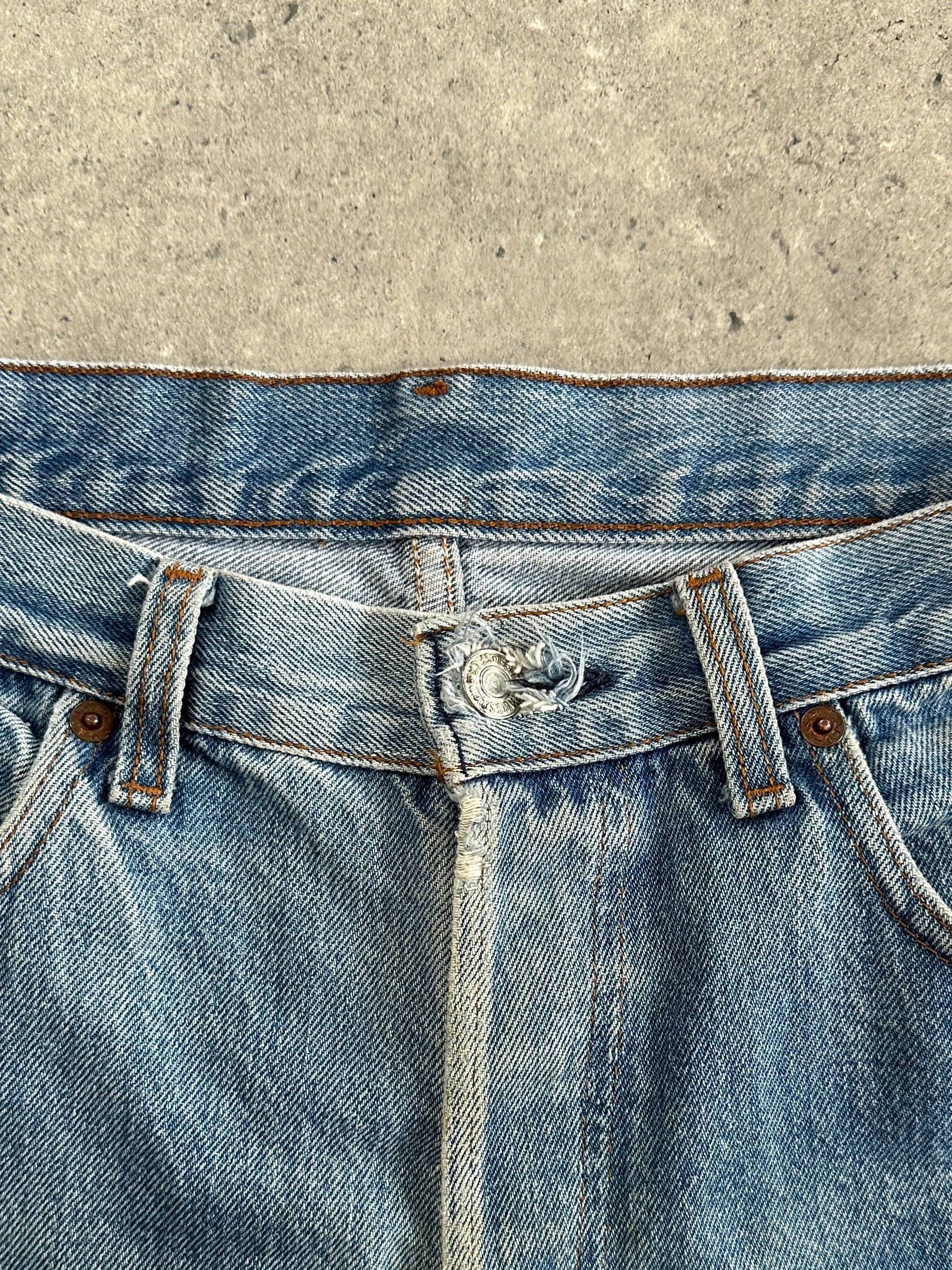 Levi's 501 straight leg denim jeans in W32 laid flat, showing classic blue wash and iconic five-pocket design.