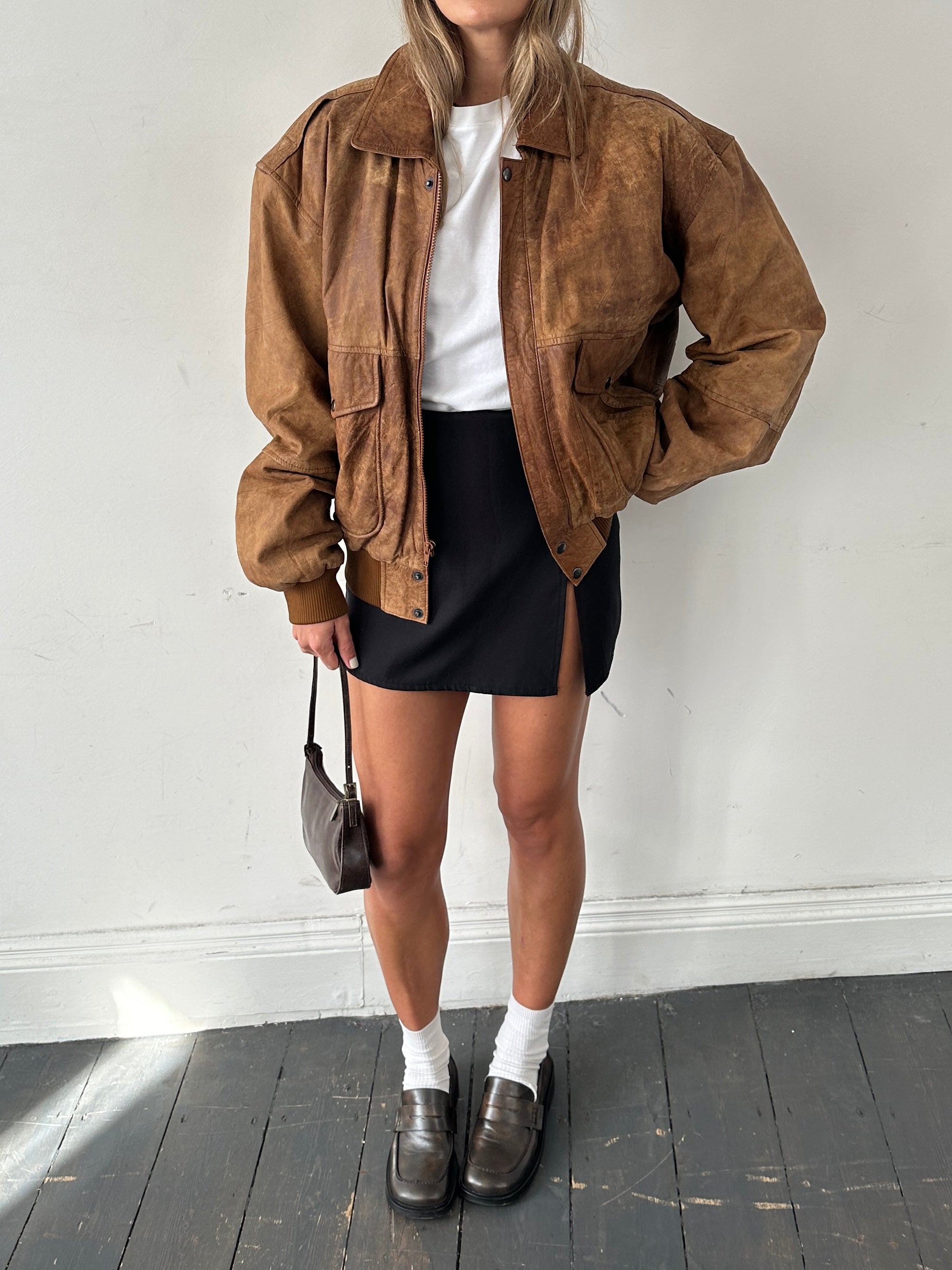 Vintage aged leather bomber jacket in XL with distressed finish, classic collar, and ribbed cuffs, styled for a rugged look.