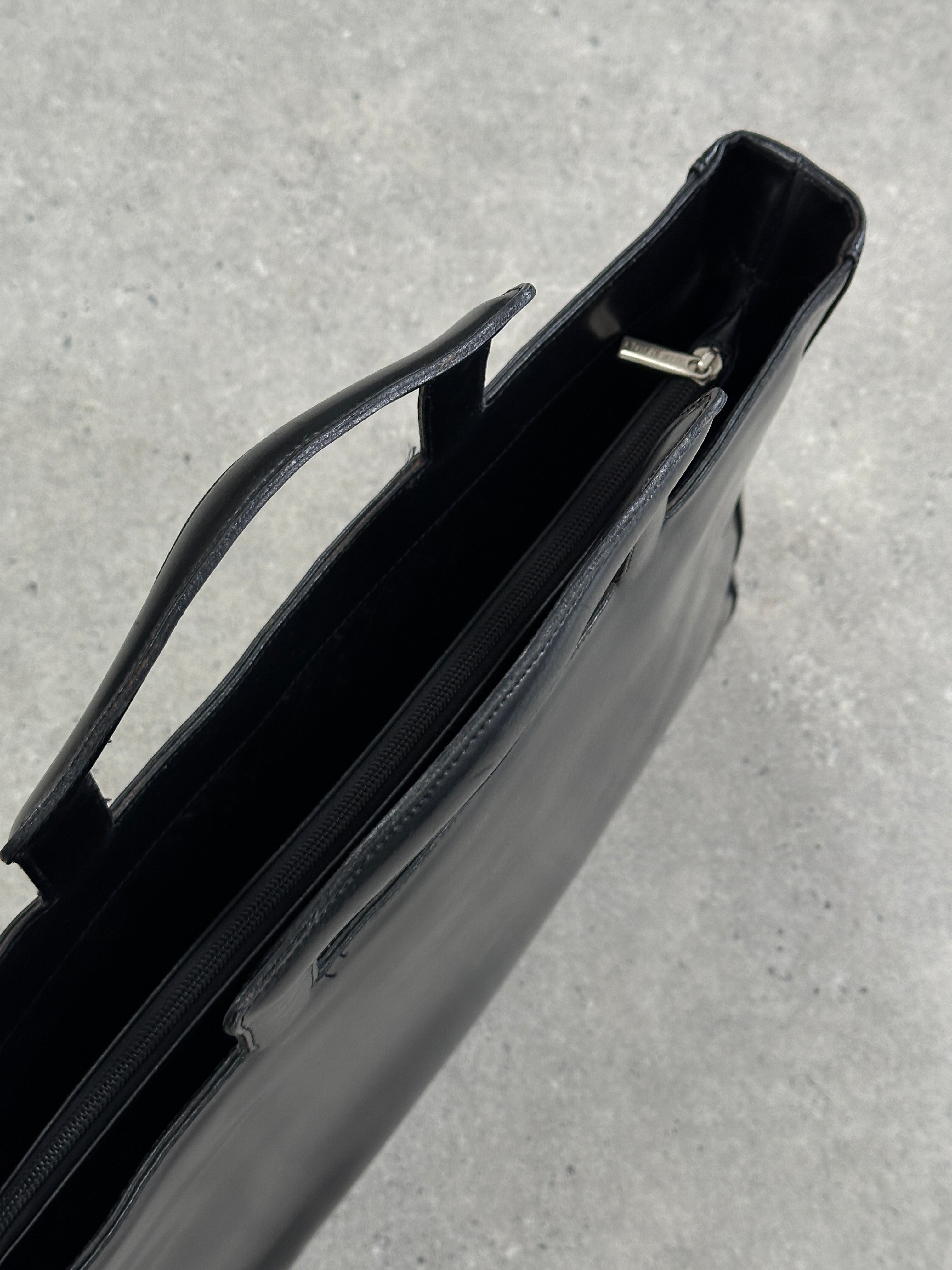 Vintage Italian leather briefcase bag with handles and brass hardware, showcasing a classic, timeless design suitable for professionals.