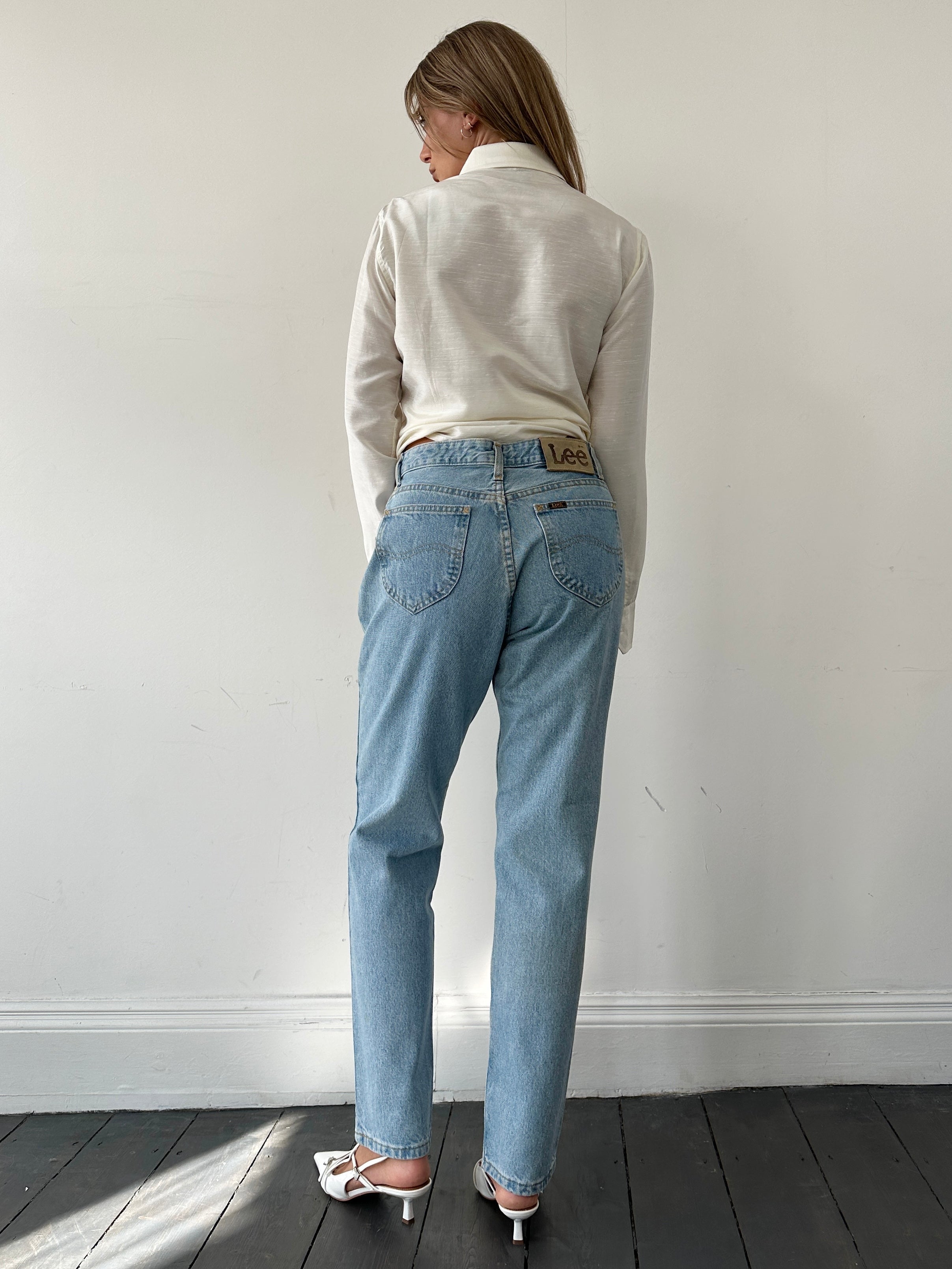 Light wash Lee high-waisted denim jeans in size W30 displayed on a mannequin with front pockets and classic stitching.