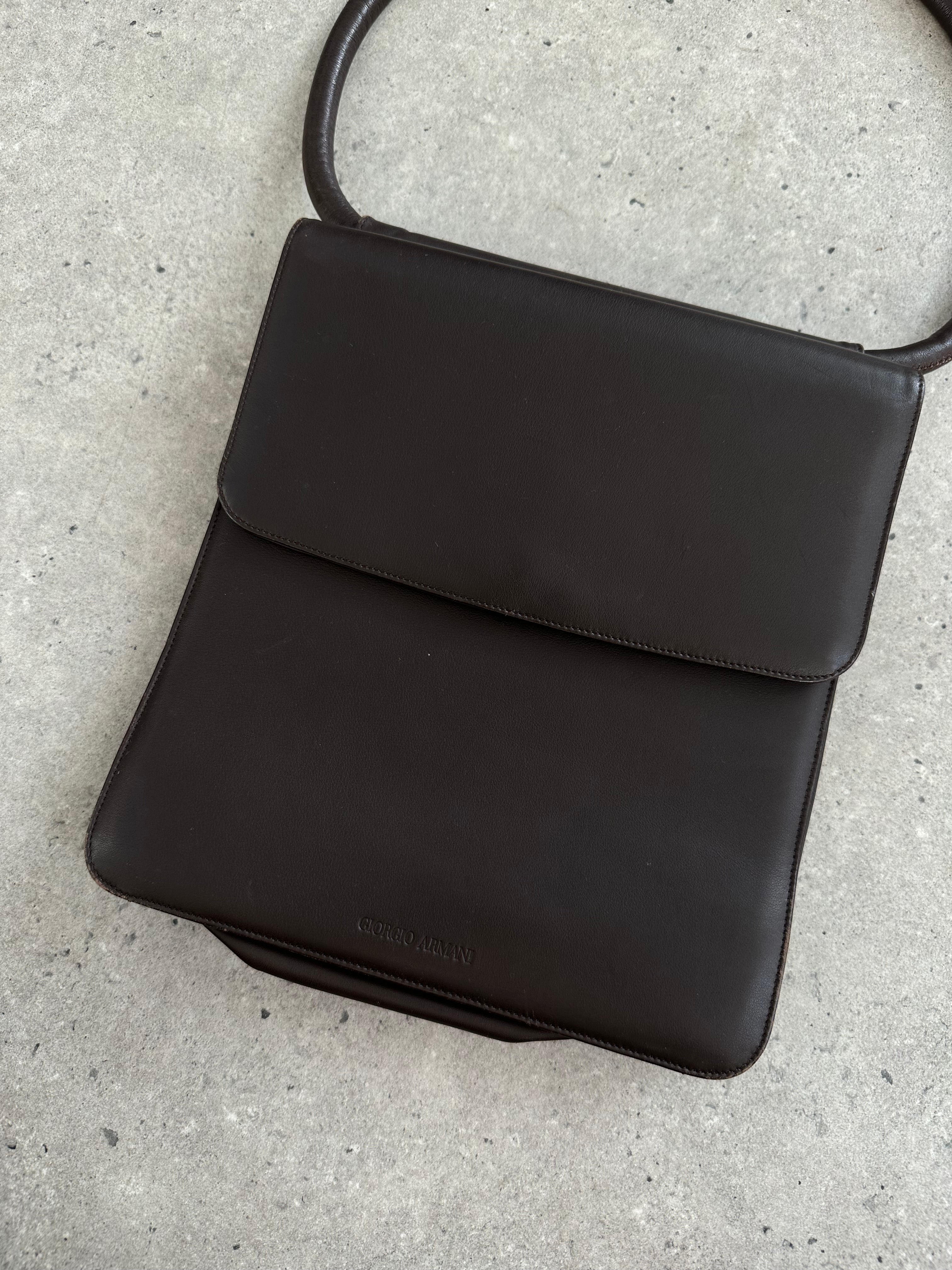 Giorgio Armani Le Collezioni leather shoulder bag with sleek design and adjustable strap, displayed on a neutral background.