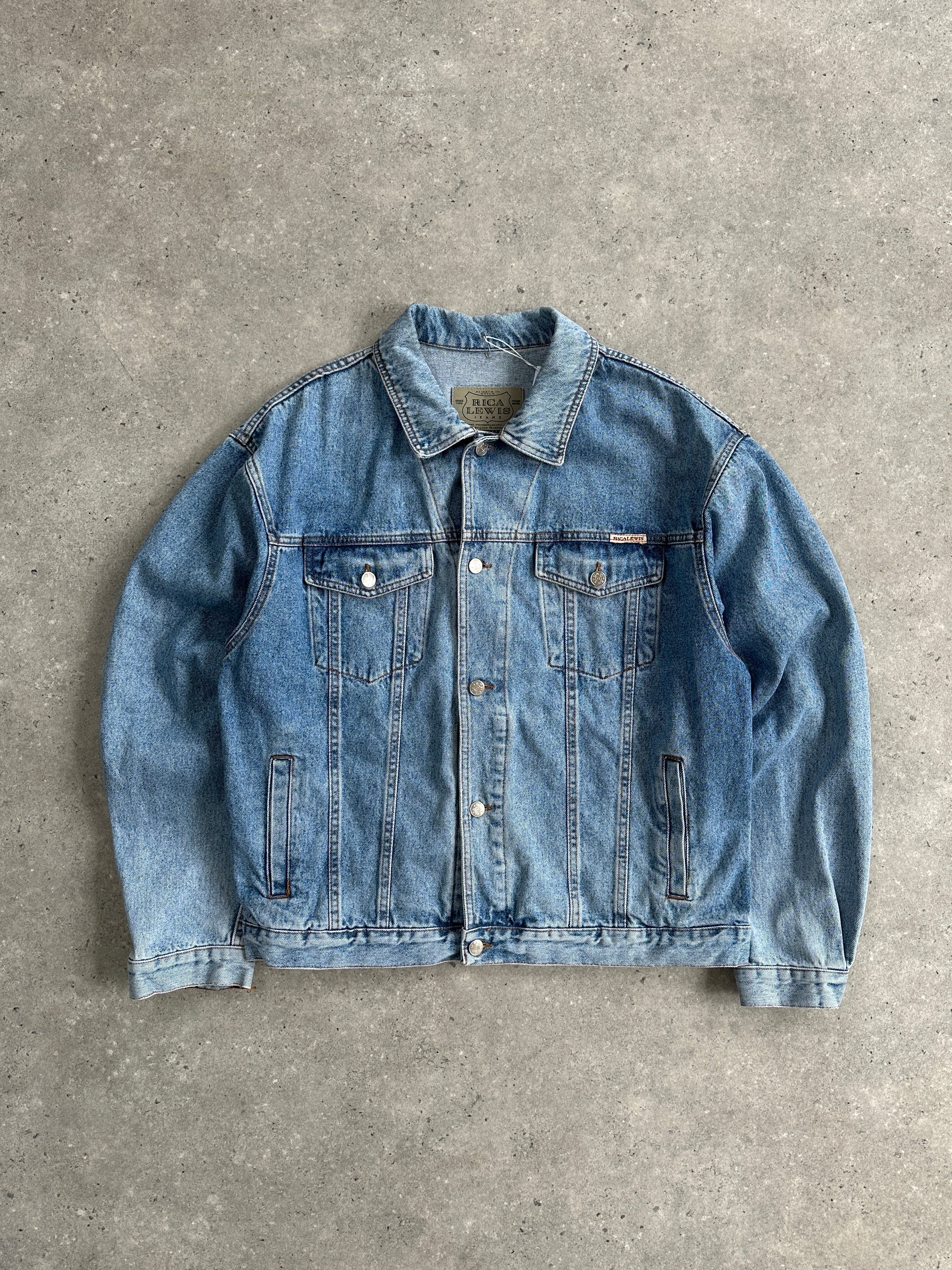 Vintage oversized denim jacket in XL, featuring classic blue wash, button-up front, and relaxed fit, displayed on a hanger.