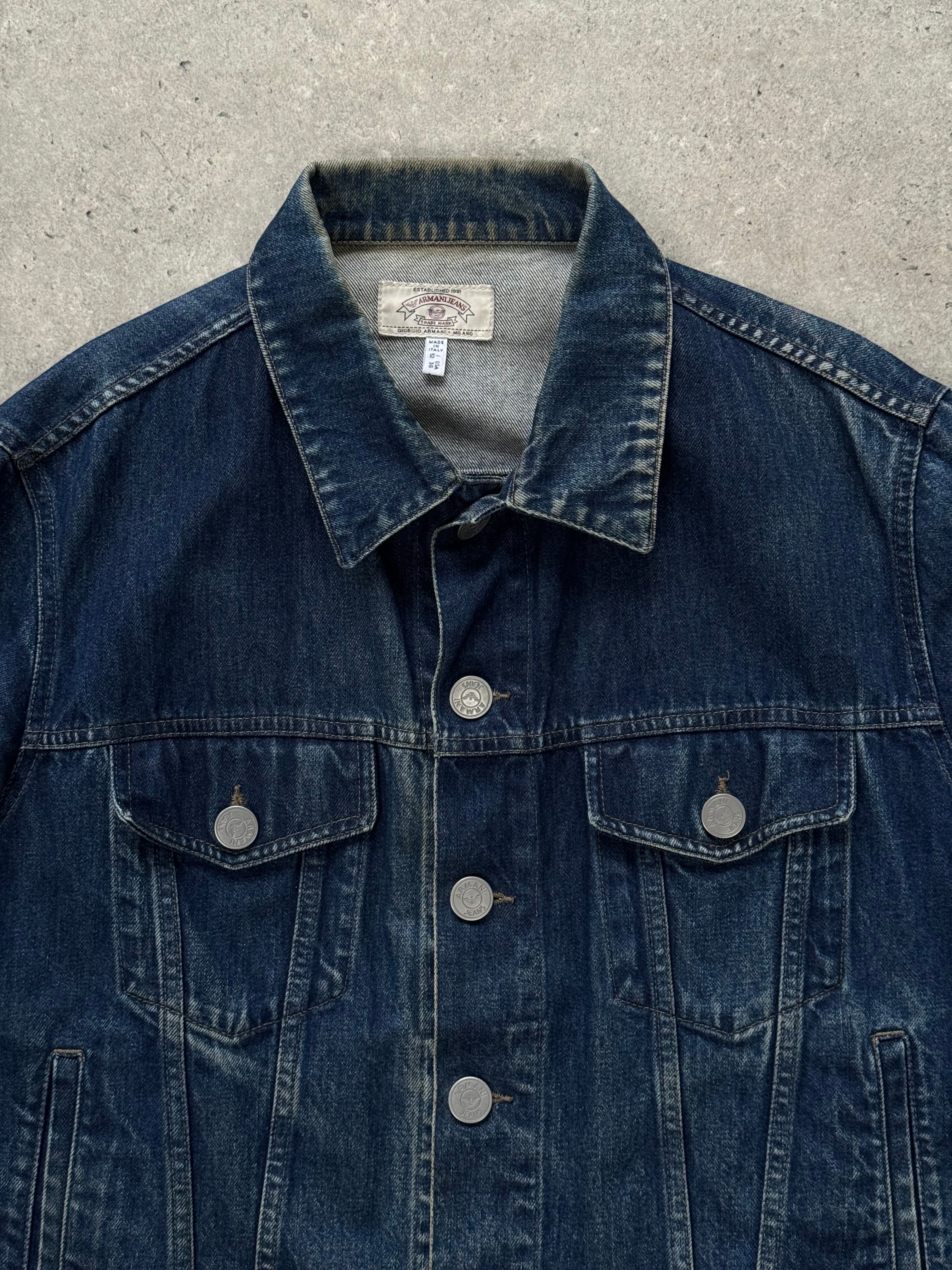 Armani Jeans 1900s mid-wash denim jacket displayed on a hanger, showcasing classic style and detailed stitching.