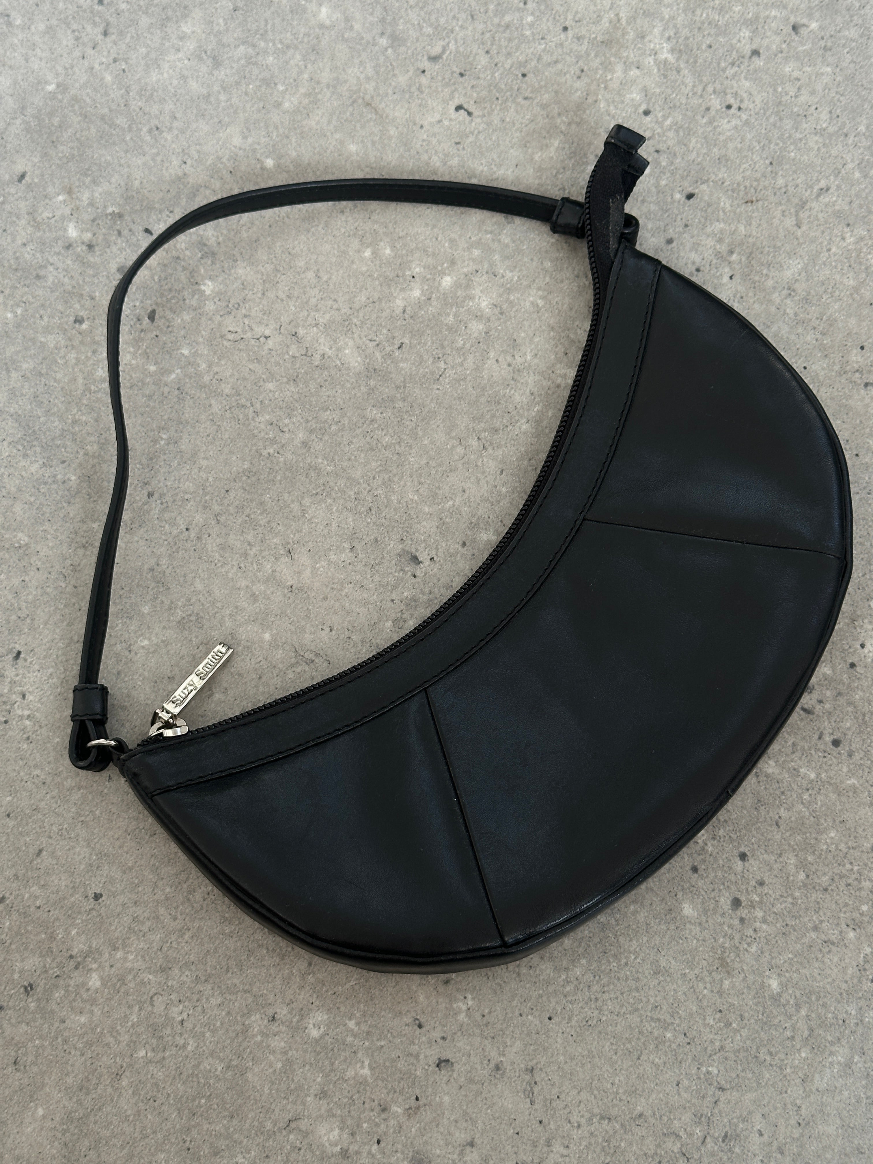 Vintage leather crescent shoulder bag with adjustable strap and classic design, perfect for stylish everyday use.