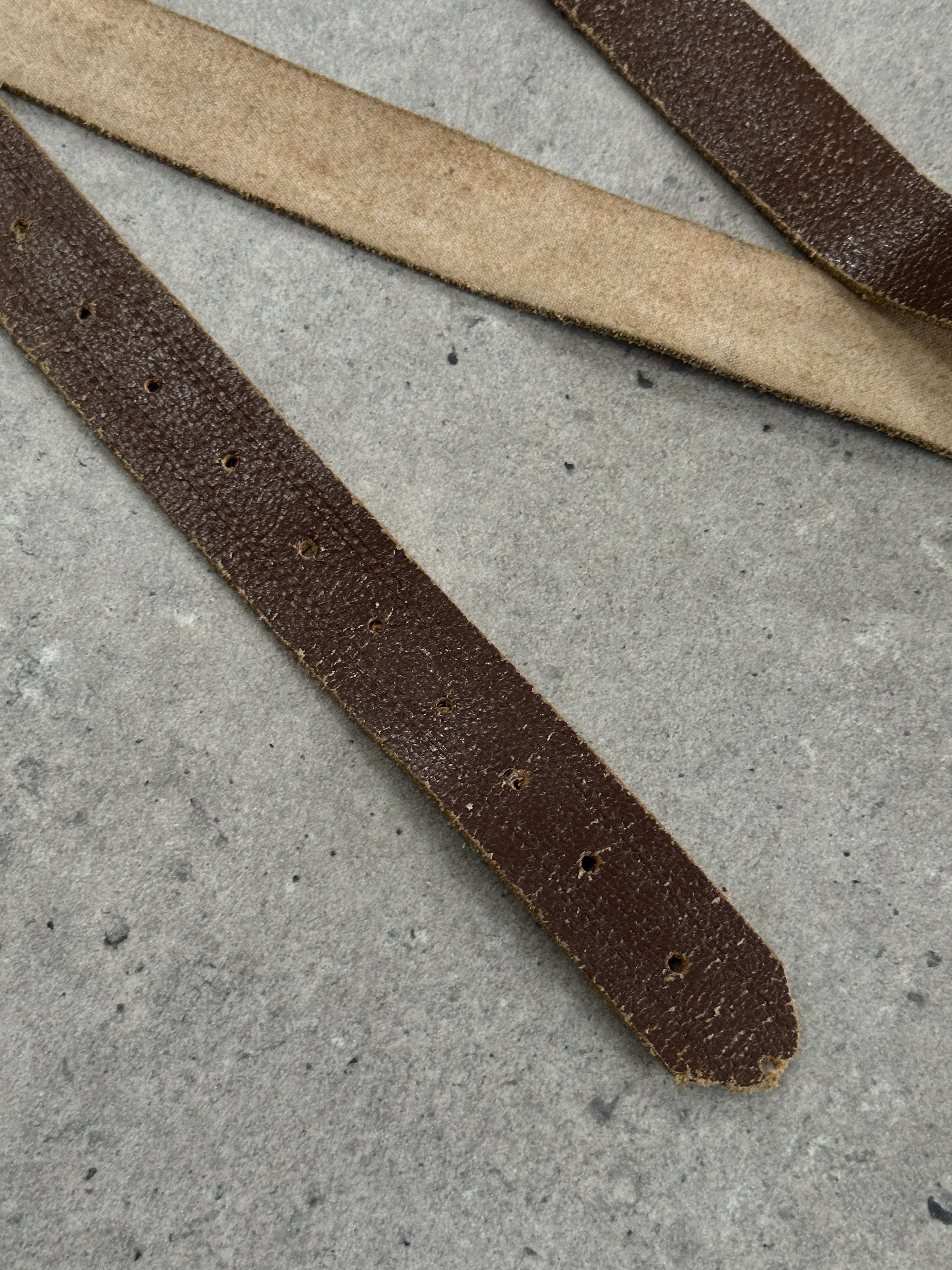 Vintage 1980s distressed slim leather belt, size W31-40, featuring a worn, rugged design with a classic buckle detail.