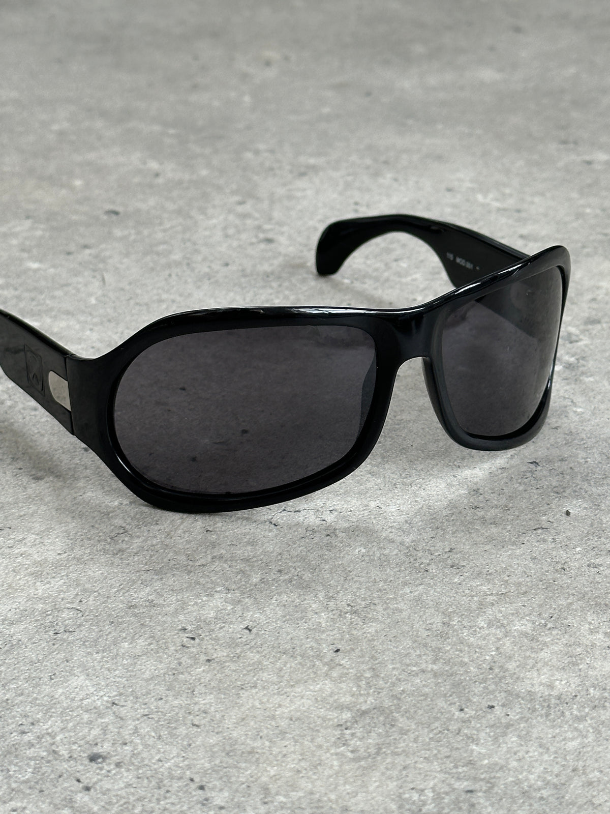 Vintage 2000s oversized shield sunglasses with bold black frames and dark lenses, stylish vintage eyewear for a retro look.