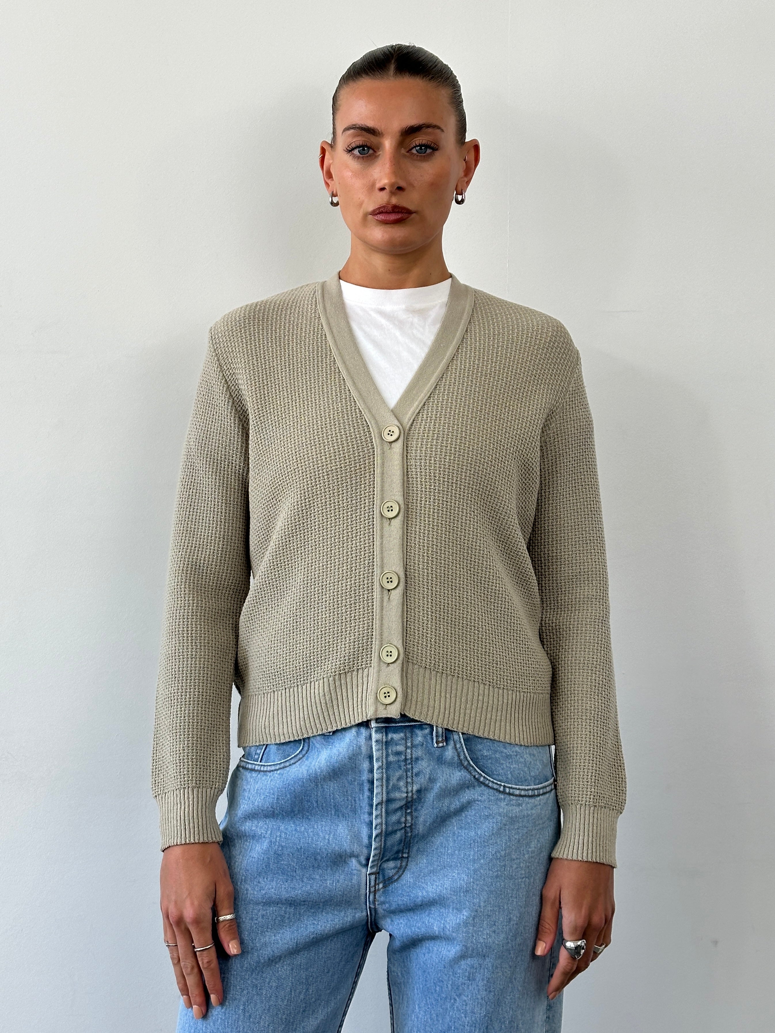 Vintage pure wool knitted cardigan in size small, featuring a classic design with button closure and cozy texture.