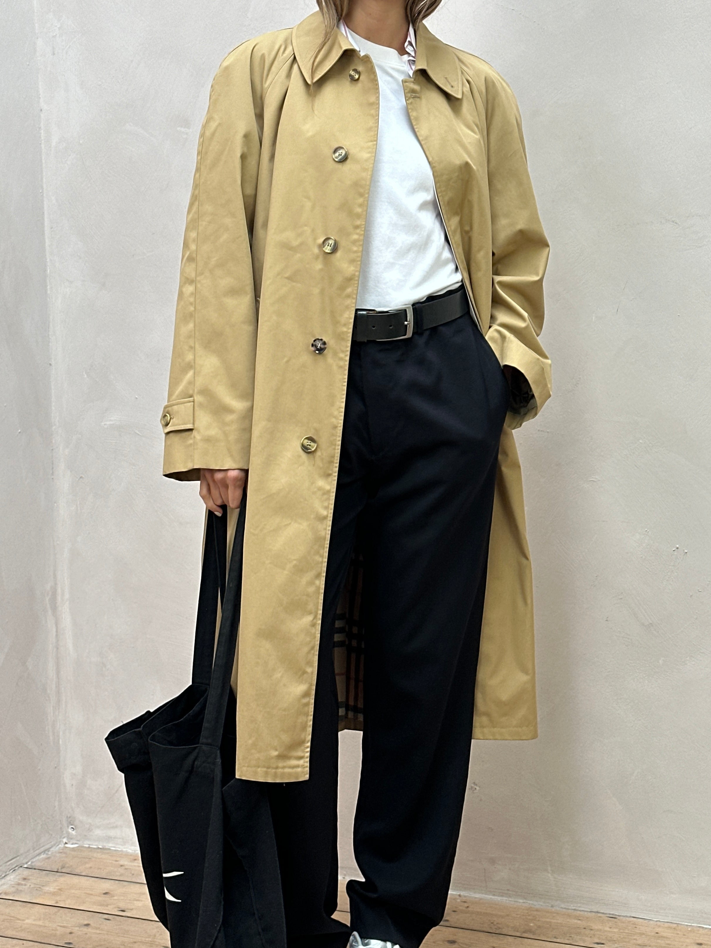 Vintage brand XL trench coat with concealed placket, belted waist, classic beige fabric, and tailored design.