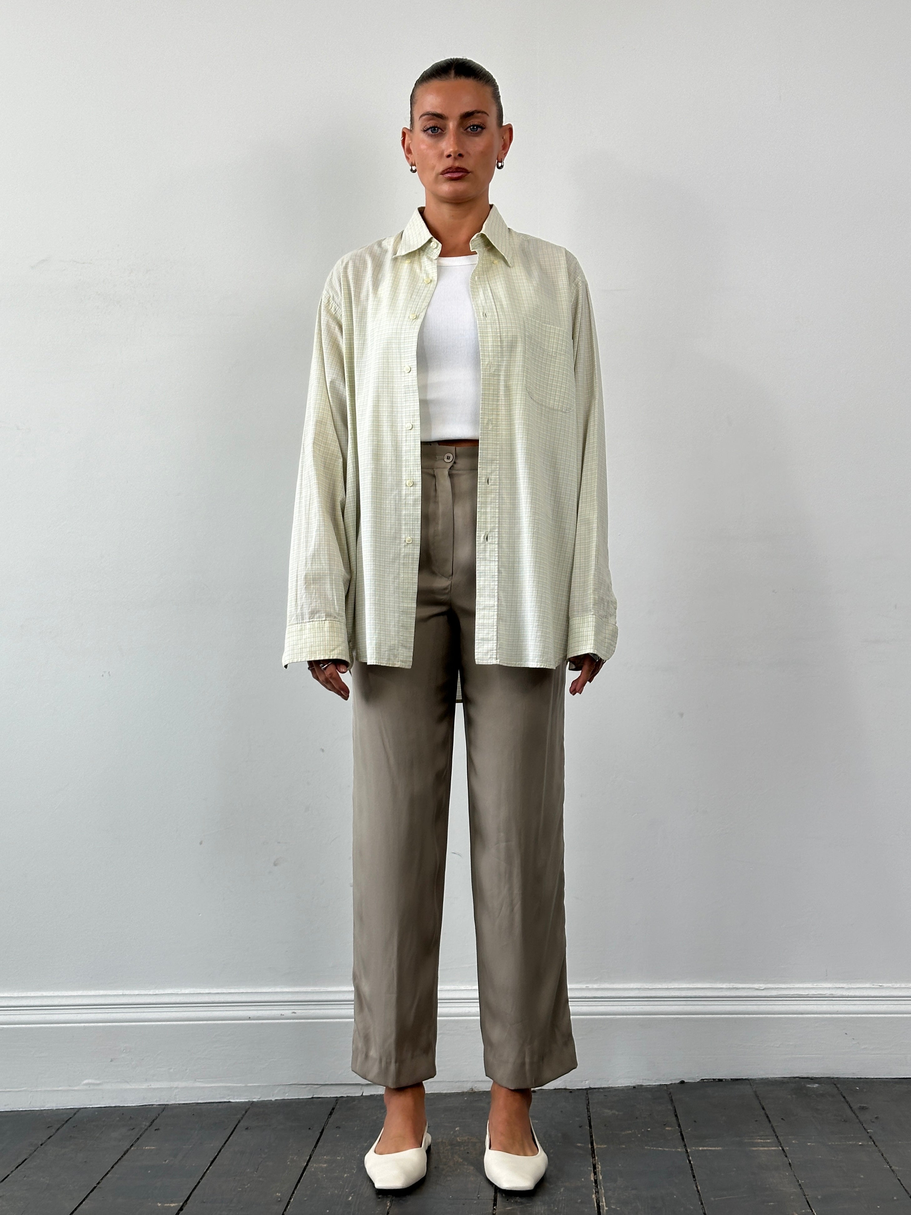 Mani Pure Silk high-waisted trousers in W26, shown in a natural pose, highlighting the sleek silk fabric and tailored fit.