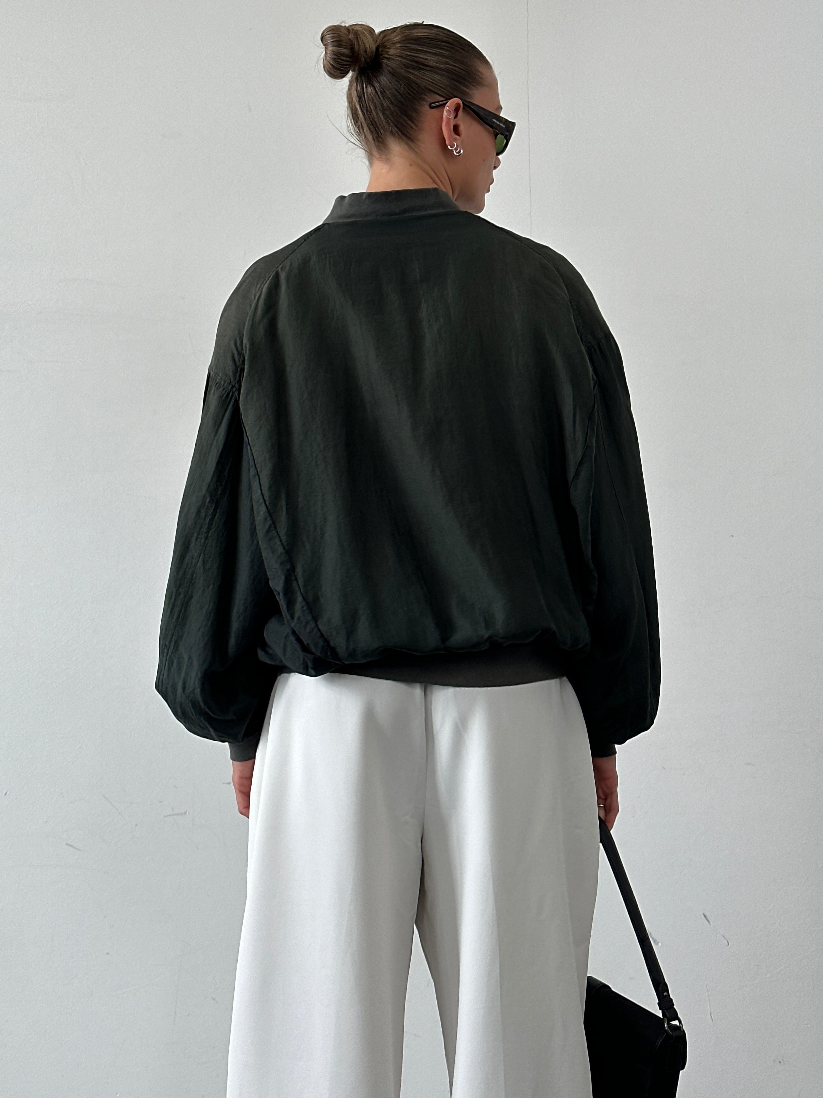 Vintage pure silk bomber jacket in size L, showcasing smooth fabric and classic bomber silhouette with ribbed cuffs and collar.