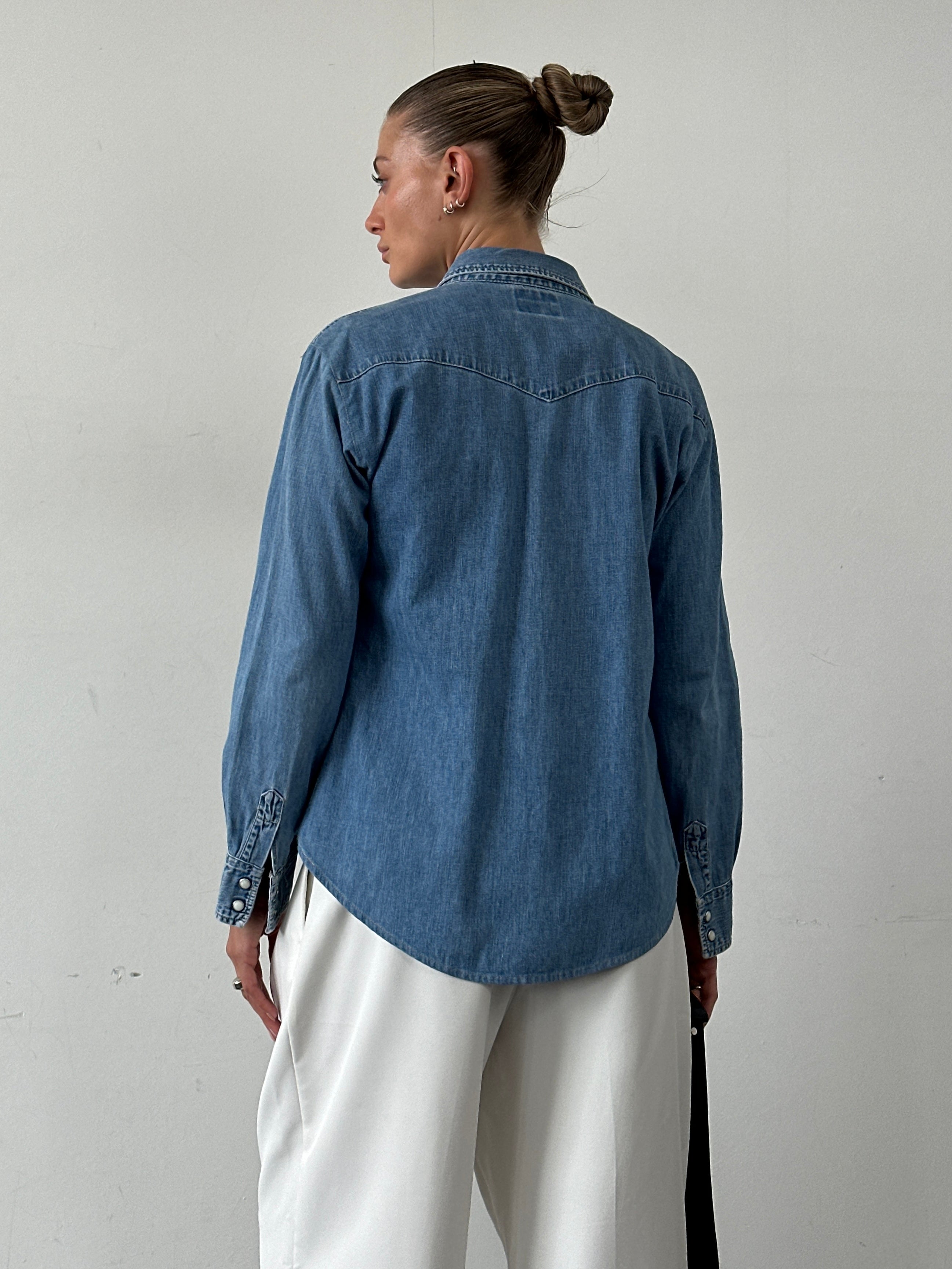 Levi’s cotton button-up denim shirt in size M, featuring classic blue denim fabric and a collared design.