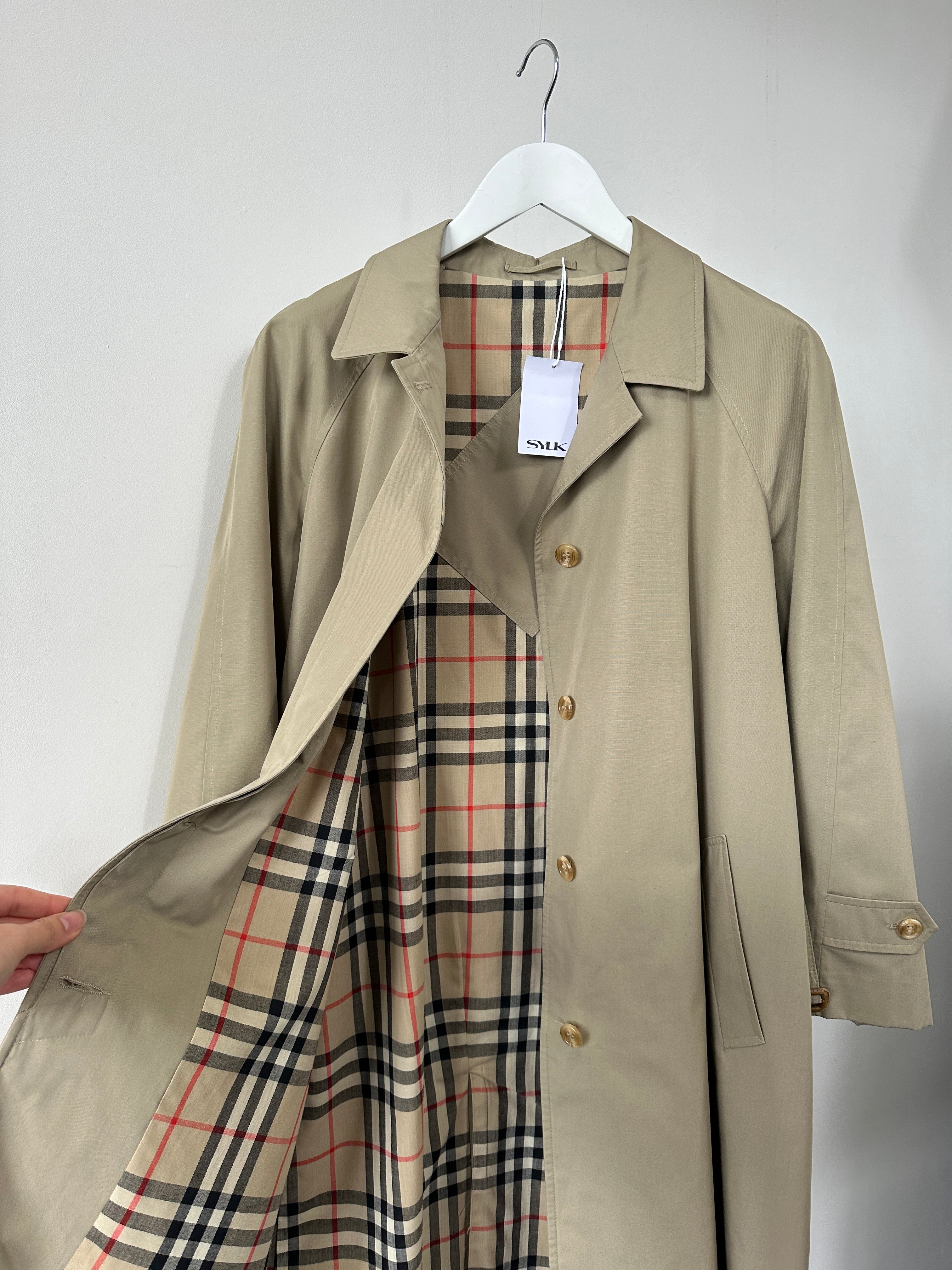 Vintage showerproof belted trench coat in size M with classic design and tailored fit, ideal for rainy weather.