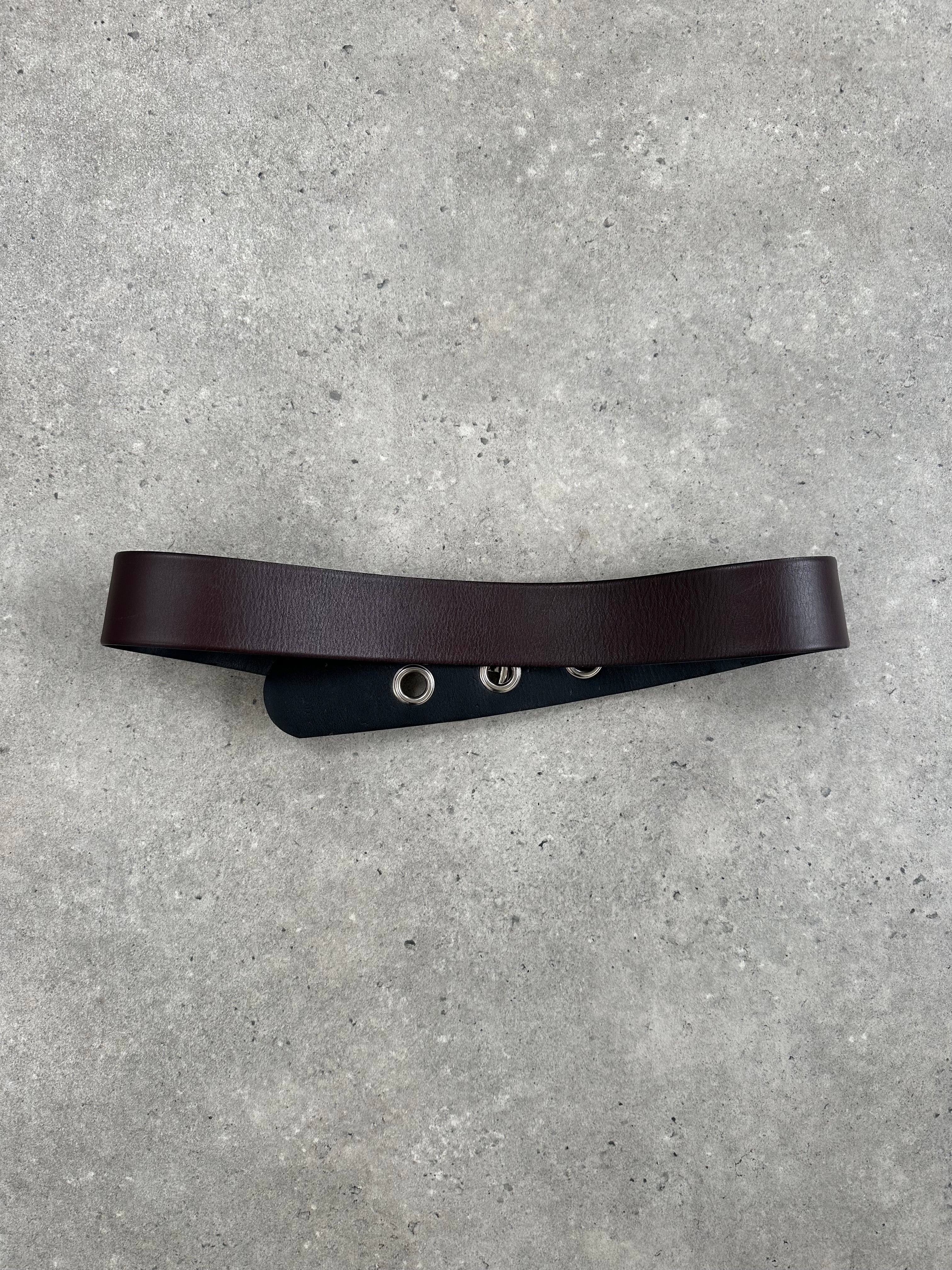 Vintage 1990s eyelet leather belt with adjustable W28-34, featuring metal eyelets and classic style, on a neutral background.