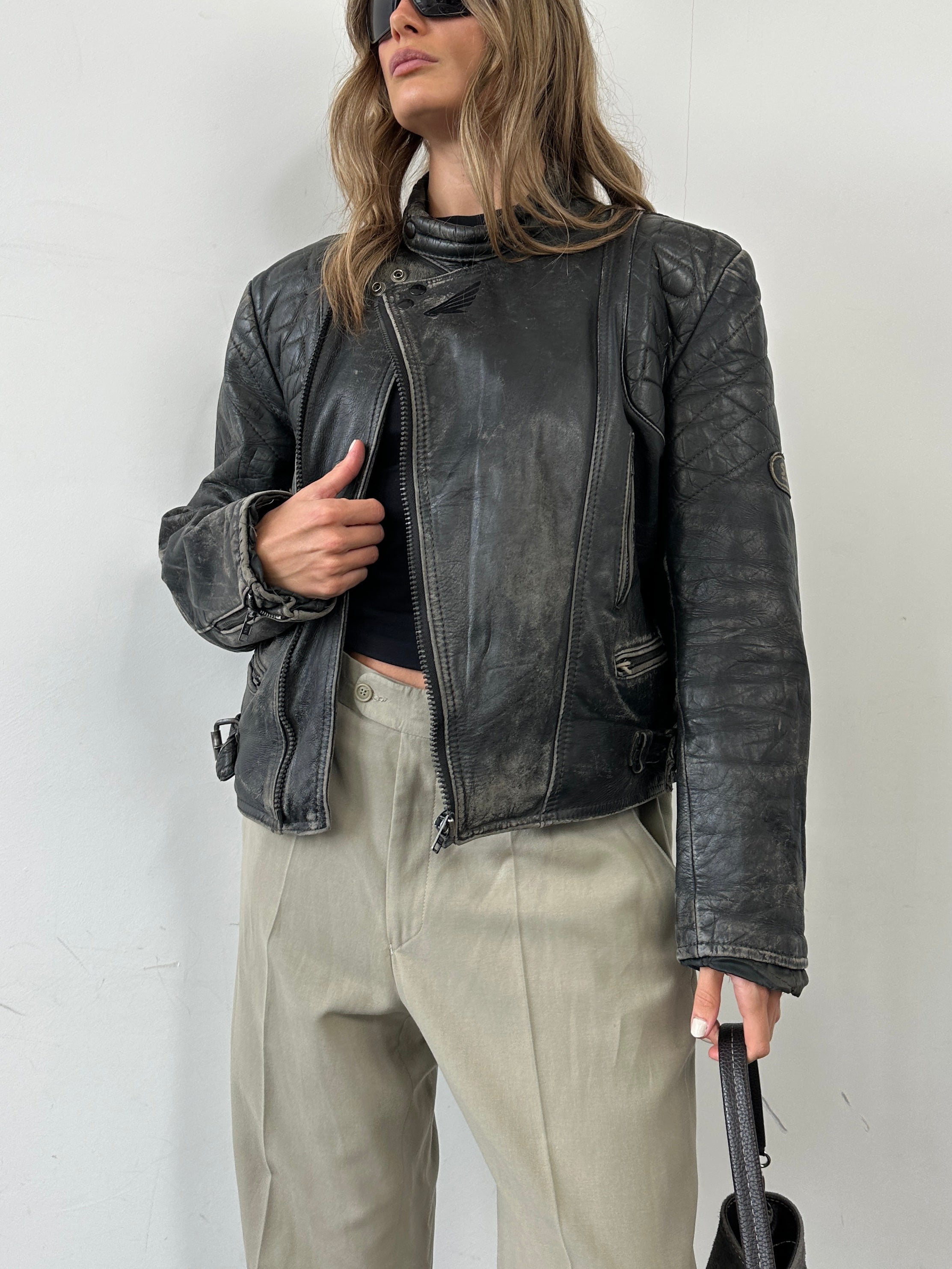 Vintage brand distressed leather motorcycle jacket, size M/L, featuring rugged style and classic design with visible leather texture.