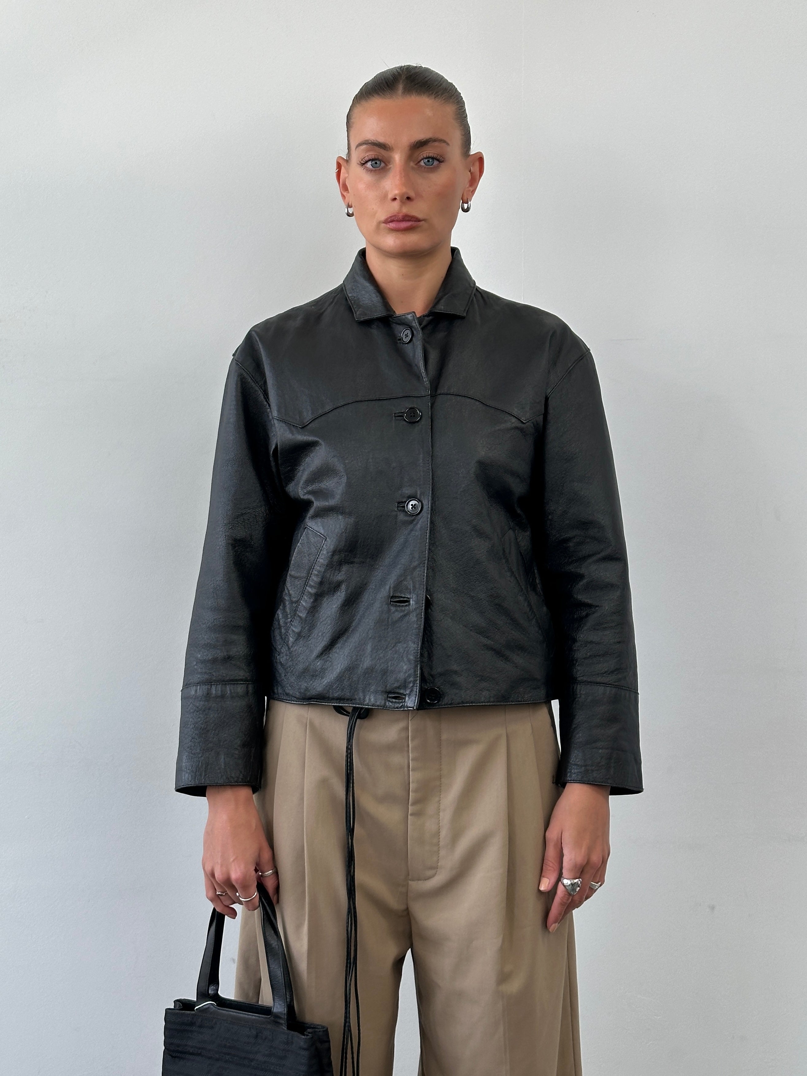 Vintage cropped leather jacket in size small, featuring classic design, quality leather, and stylish detailing.