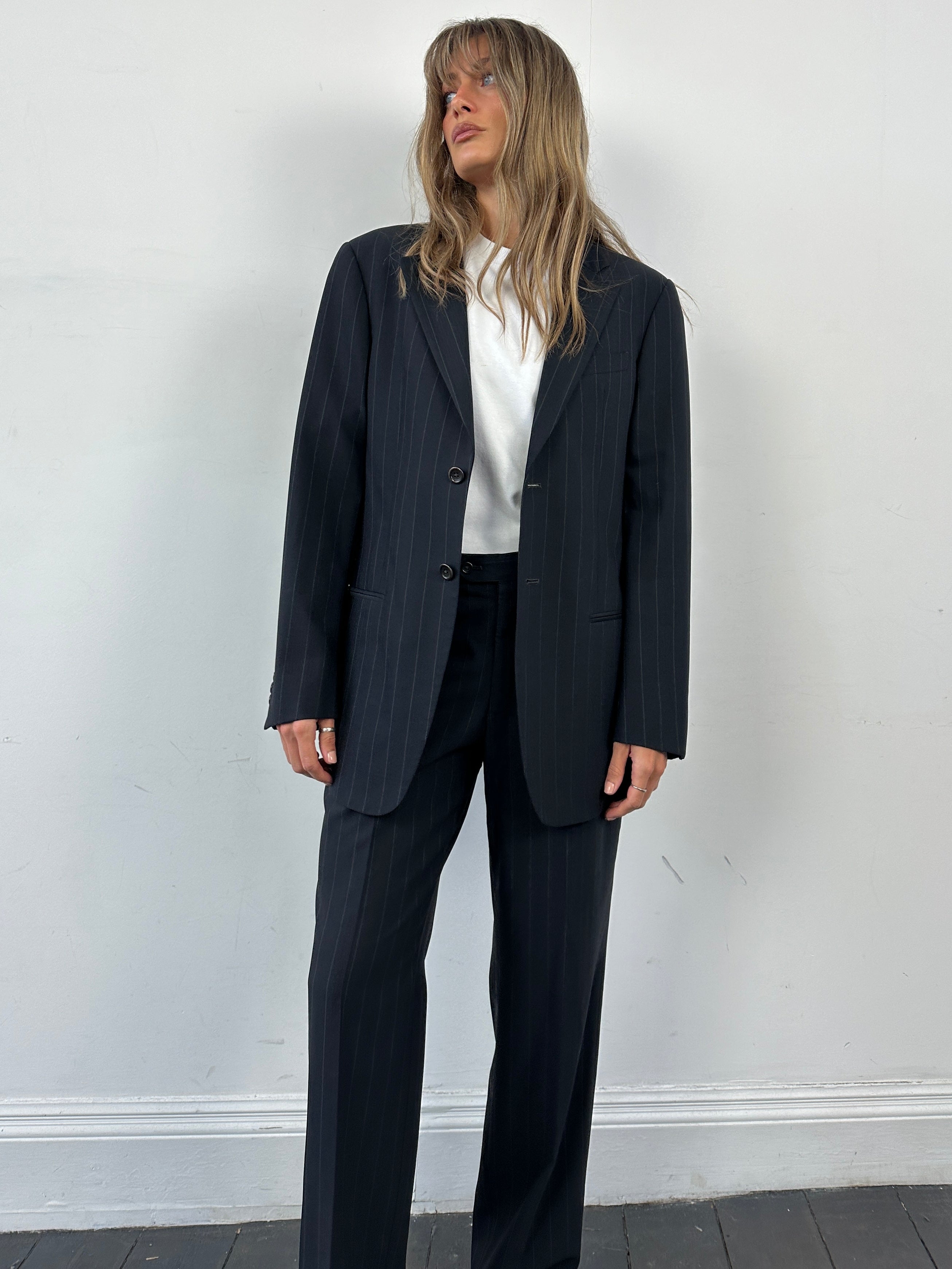 Armani Collezioni pinstripe wool jumpsuit, single-breasted with tailored fit, displayed on a hanger against a neutral background.