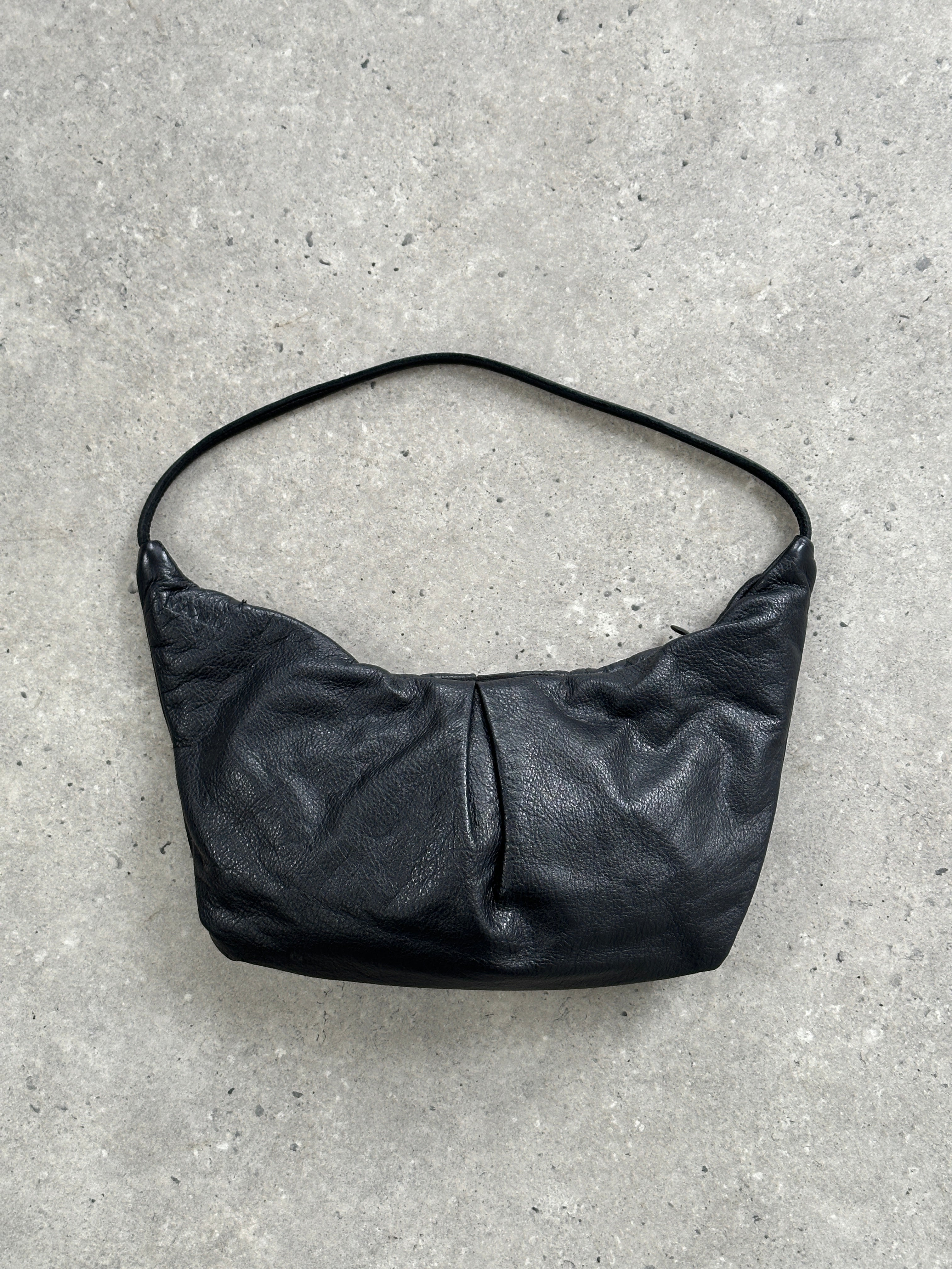MAX & Co leather crescent shoulder bag with sleek design and adjustable strap, featuring a smooth finish and modern style.