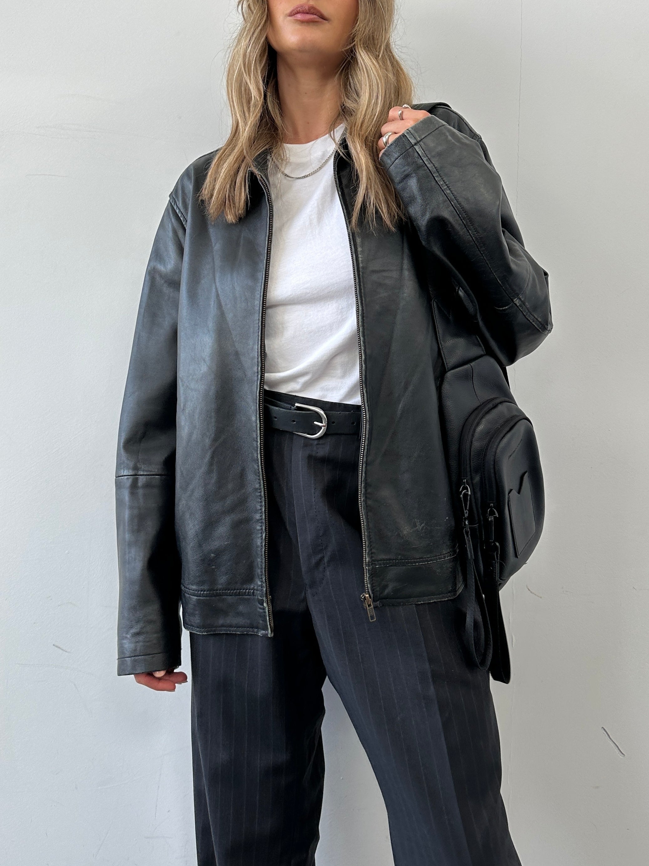 Conbipel minimal leather jacket in size L, featuring a sleek black design with clean lines and a classic collar.