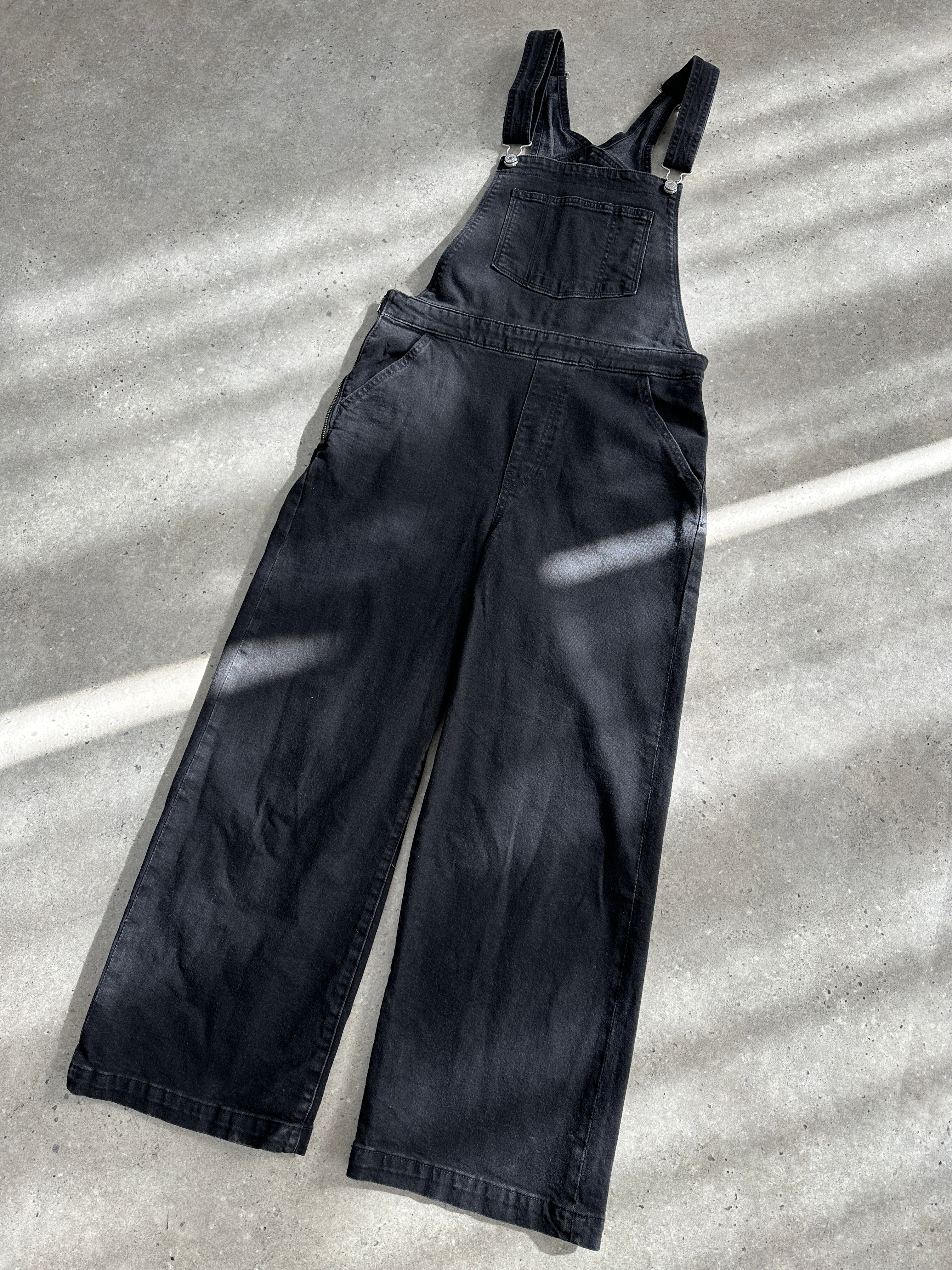 Levi’s premium denim dungarees in size M, featuring classic blue denim fabric with adjustable shoulder straps and front pockets.