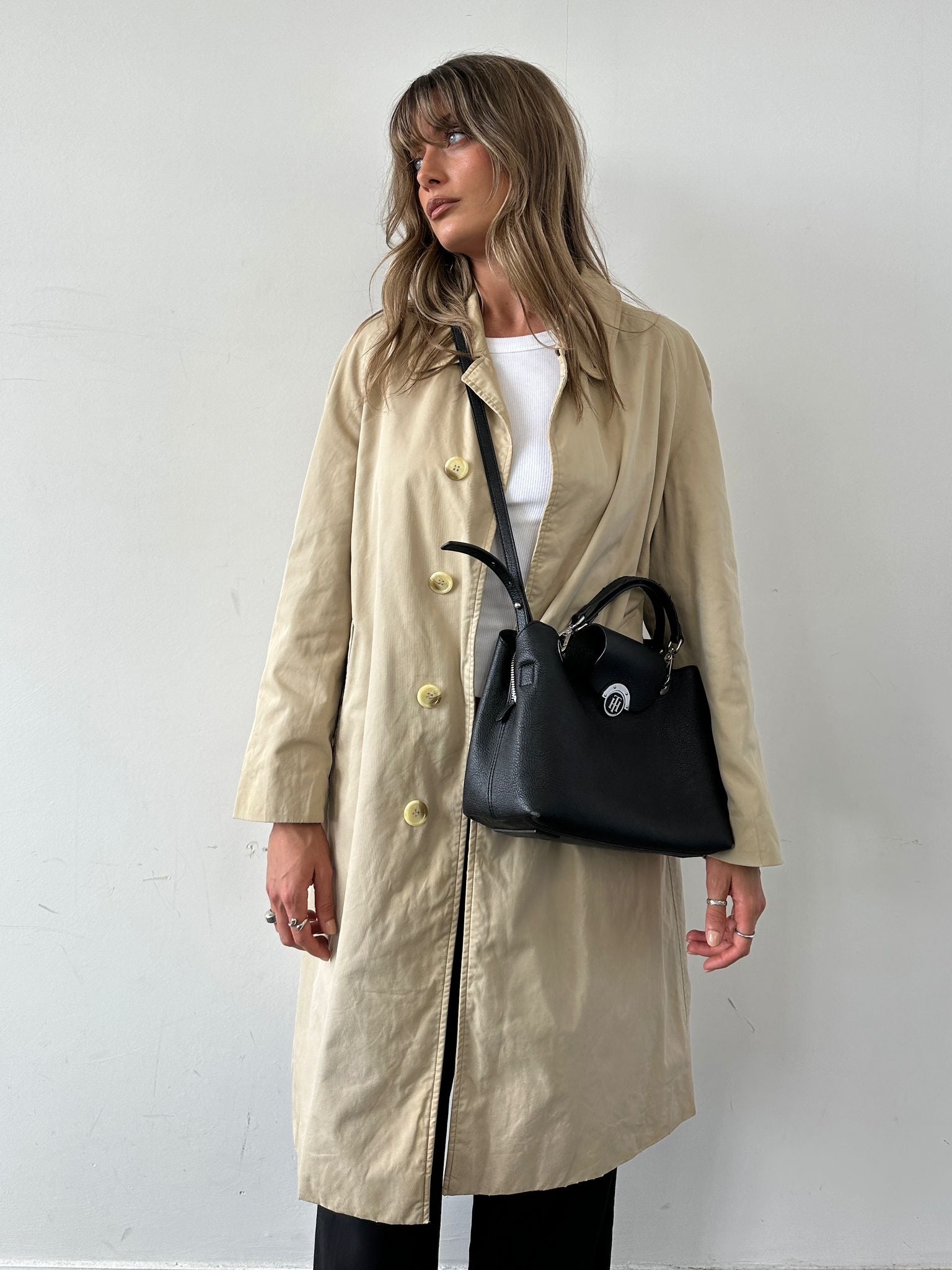 Tommy Hilfiger crossbody bag with adjustable strap, featuring classic logo and stylish design, on a neutral background.