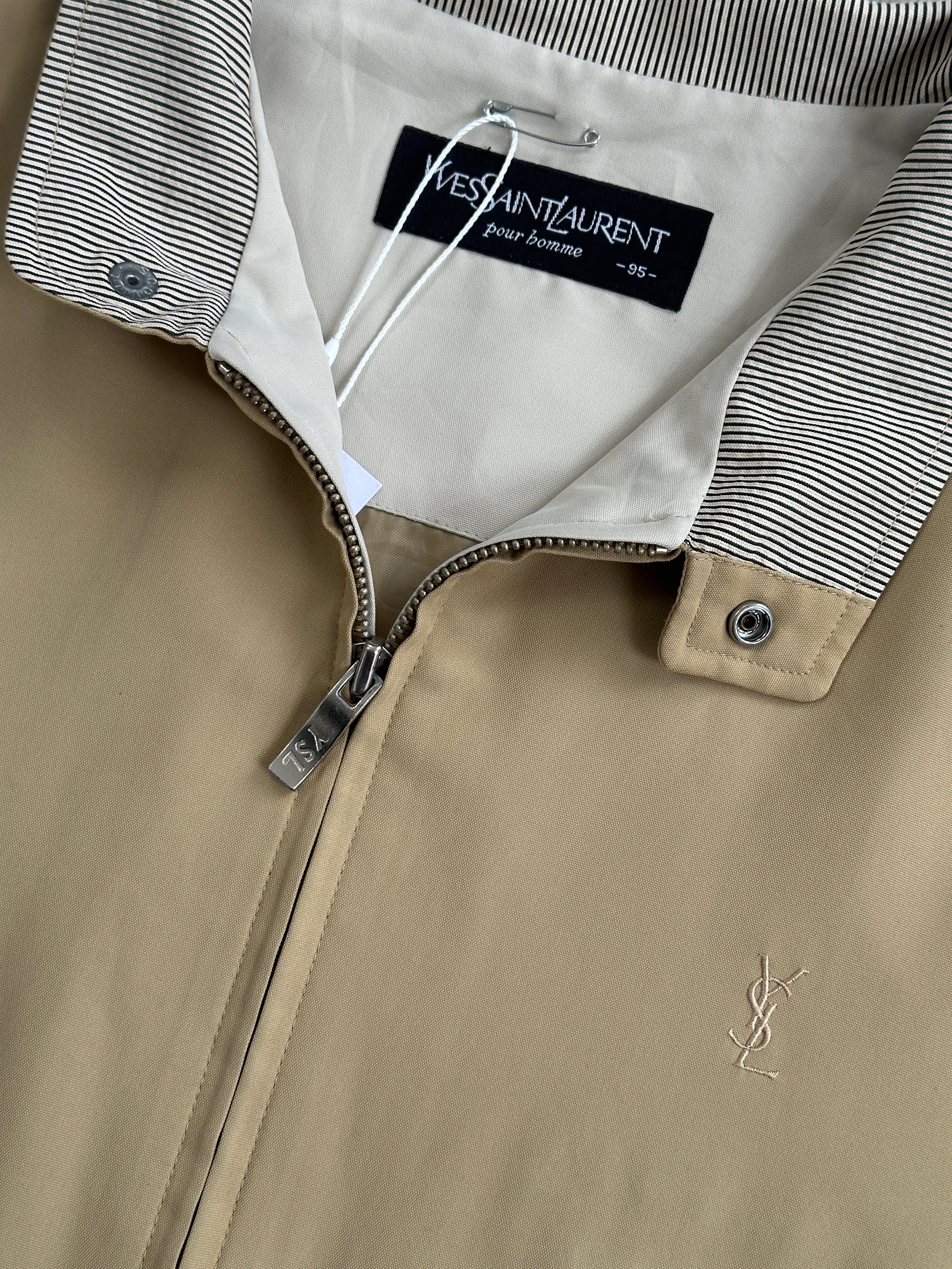 Yves Saint Laurent logo bomber jacket in black, front view showing the iconic YSL emblem and stylish design.