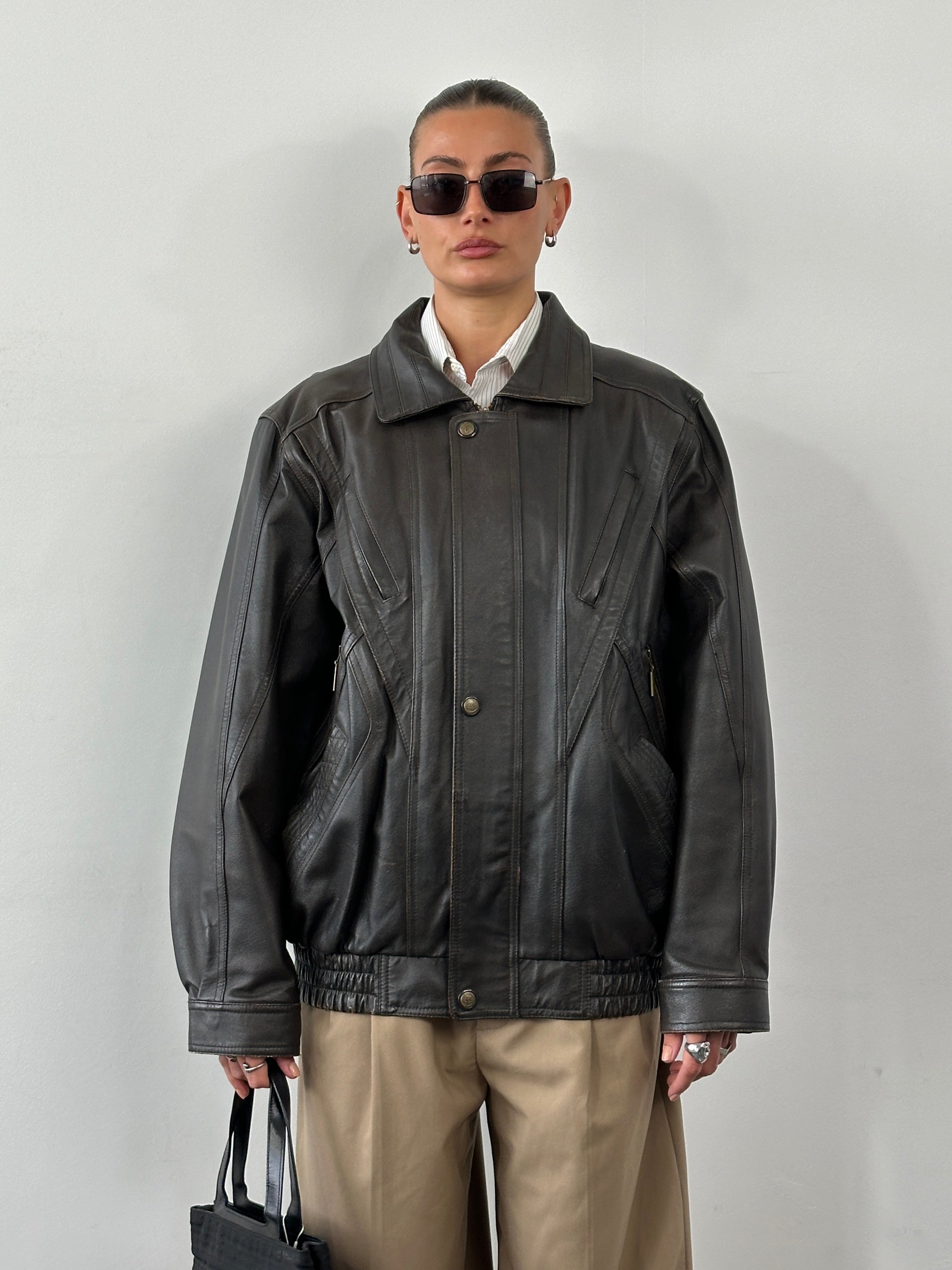 Vintage leather blouson bomber jacket in XL size, featuring classic design and detailed stitching, shown on a hanger.