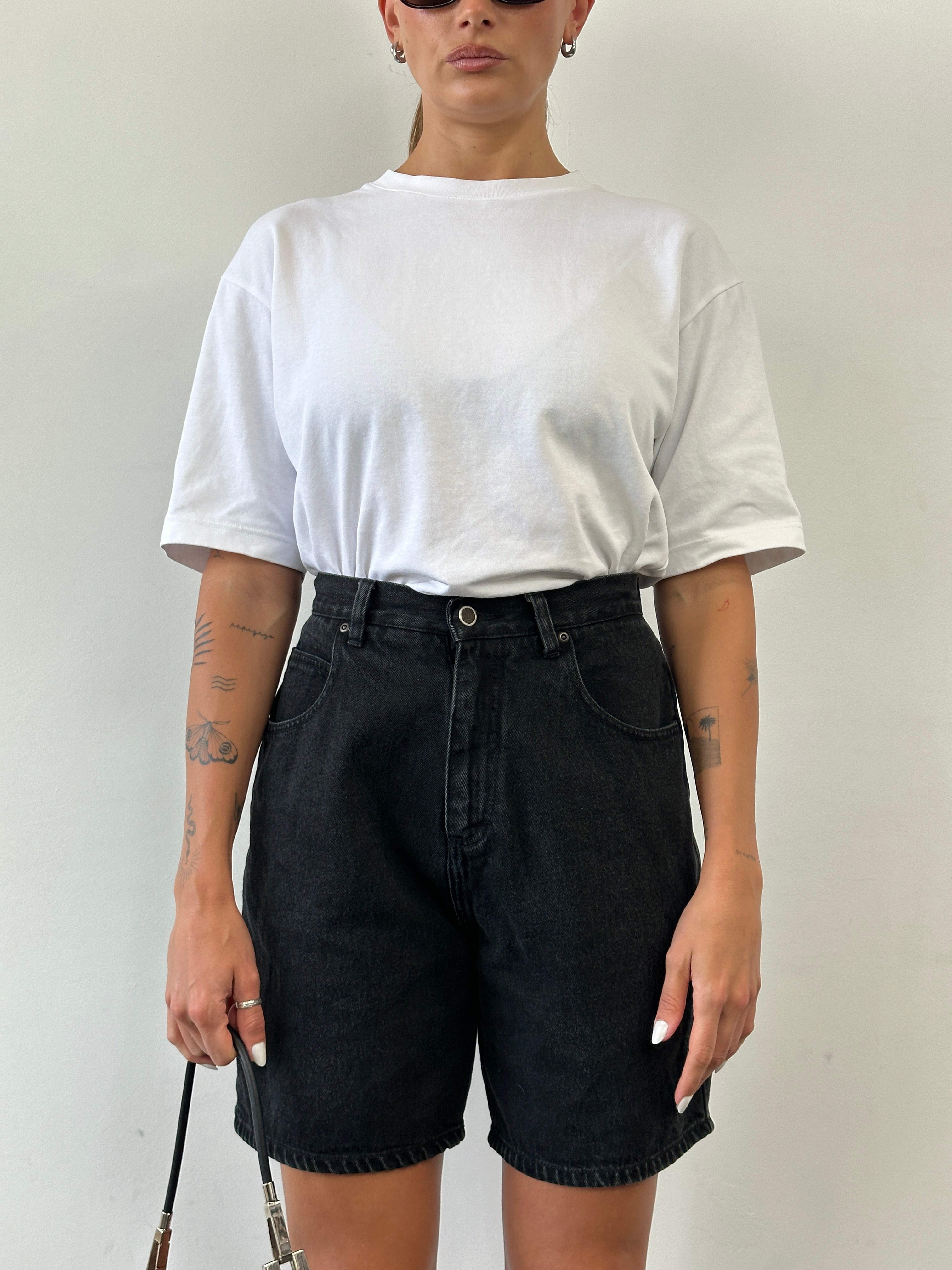 Vintage high-waisted denim shorts with frayed edges and distressed details, size W25, displayed on a neutral background.