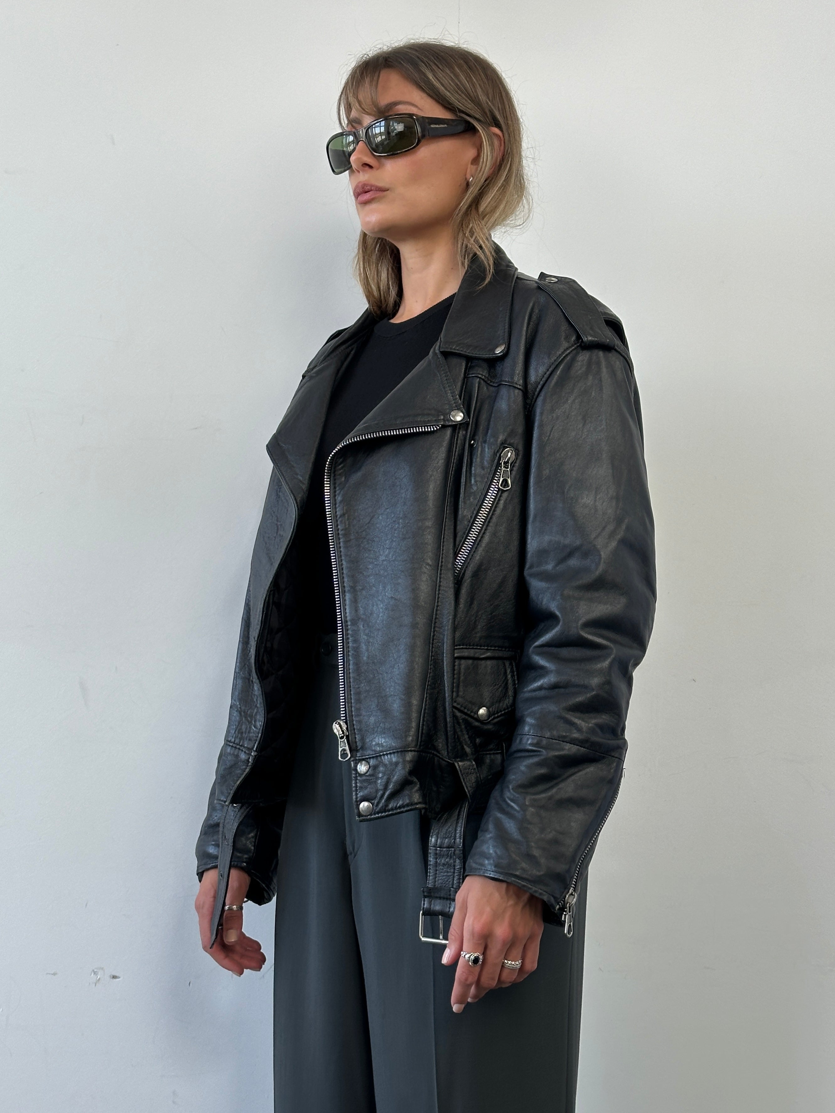 Vintage leather biker jacket in size M/L, featuring classic design with rugged leather and metal hardware details.