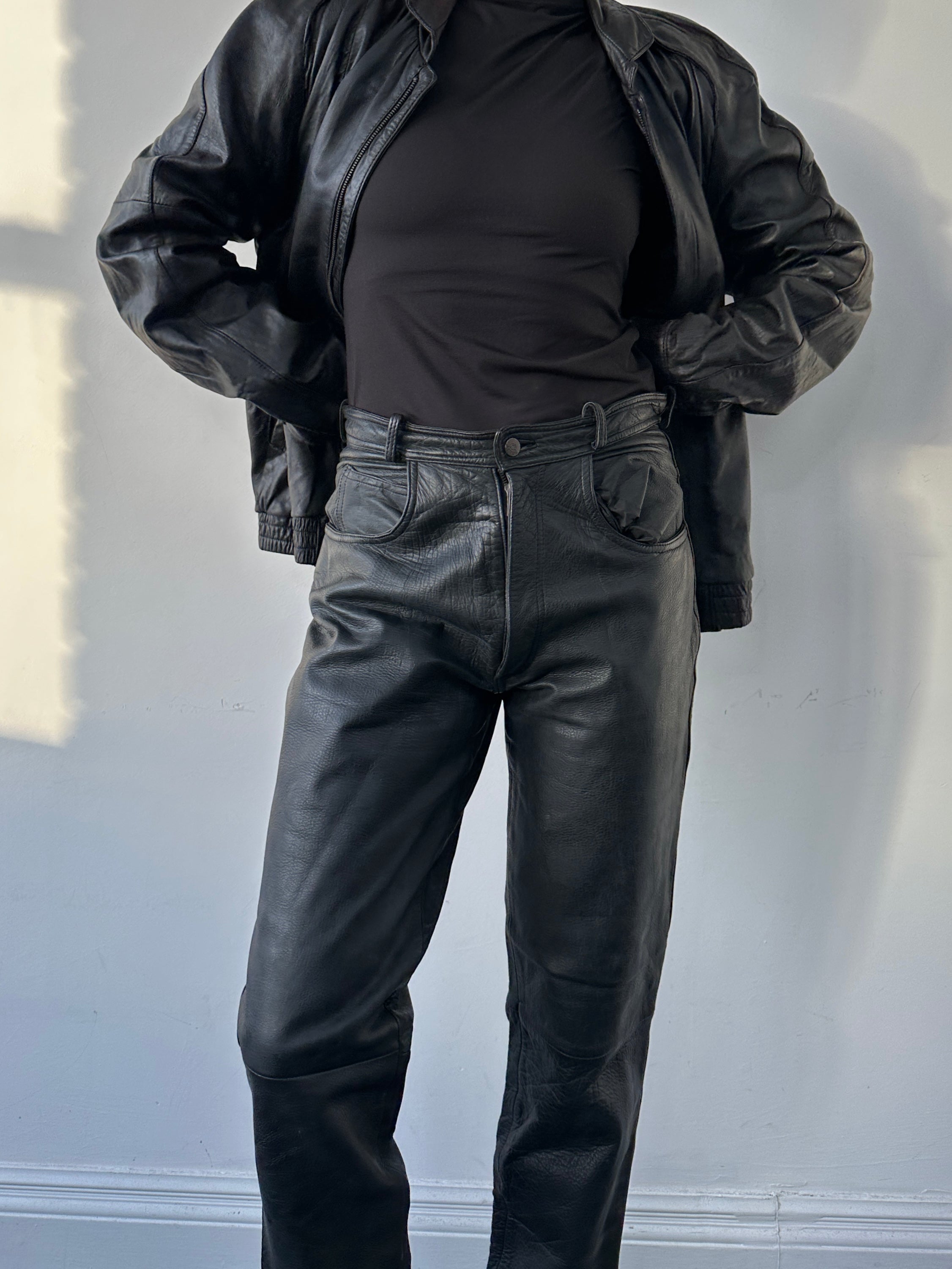 Vintage high waisted straight leg leather trousers in black, featuring classic design and tailored fit, size W28.
