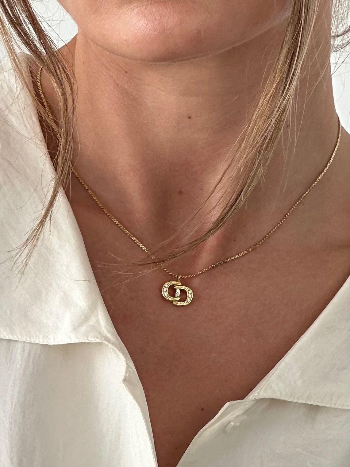 Christian Dior 16-inch gold plated rhinestone logo pendant necklace showing the sparkling Dior logo charm.