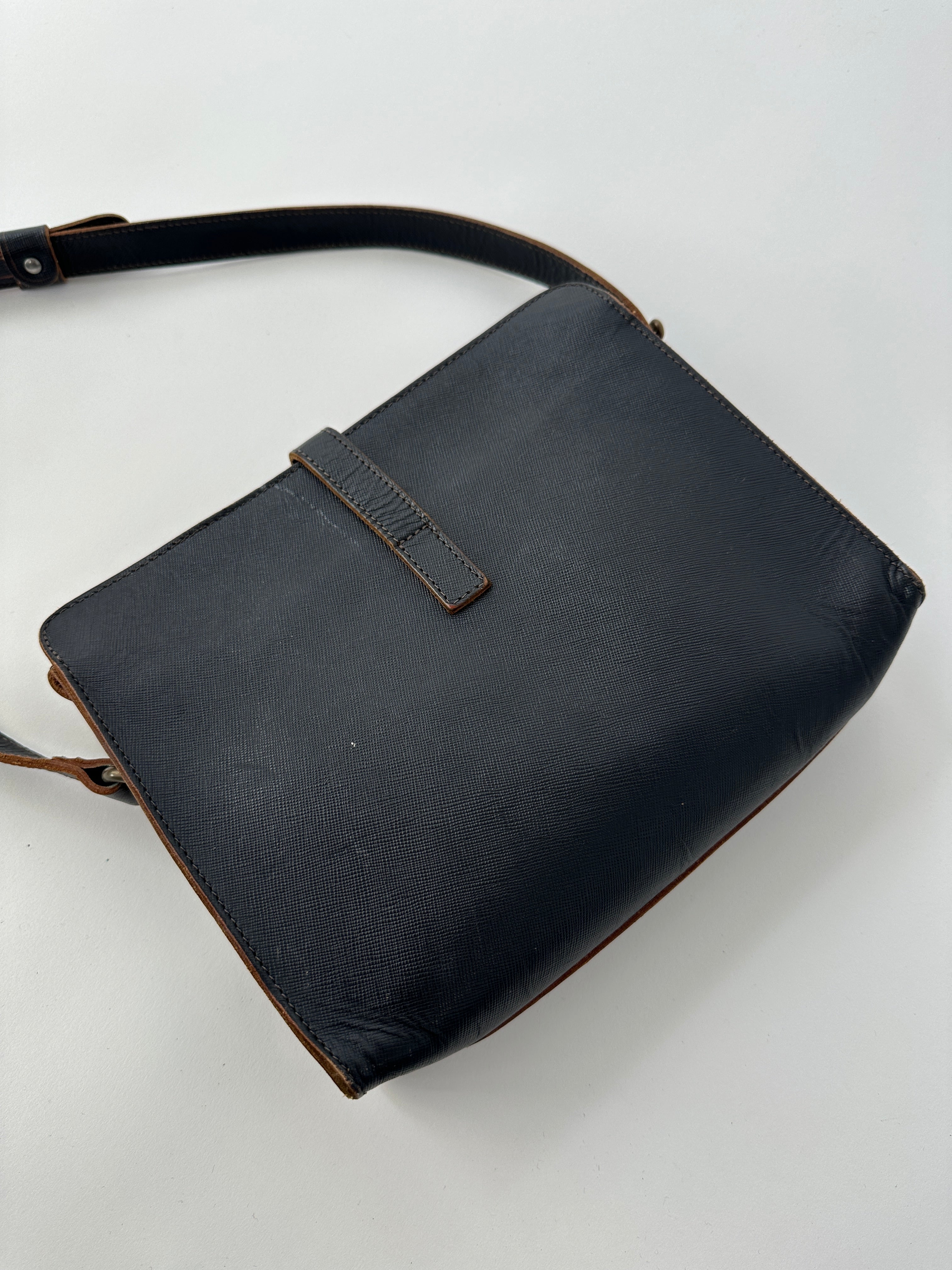 Vintage leather crossbody bag with adjustable strap, featuring a classic design and durable craftsmanship.