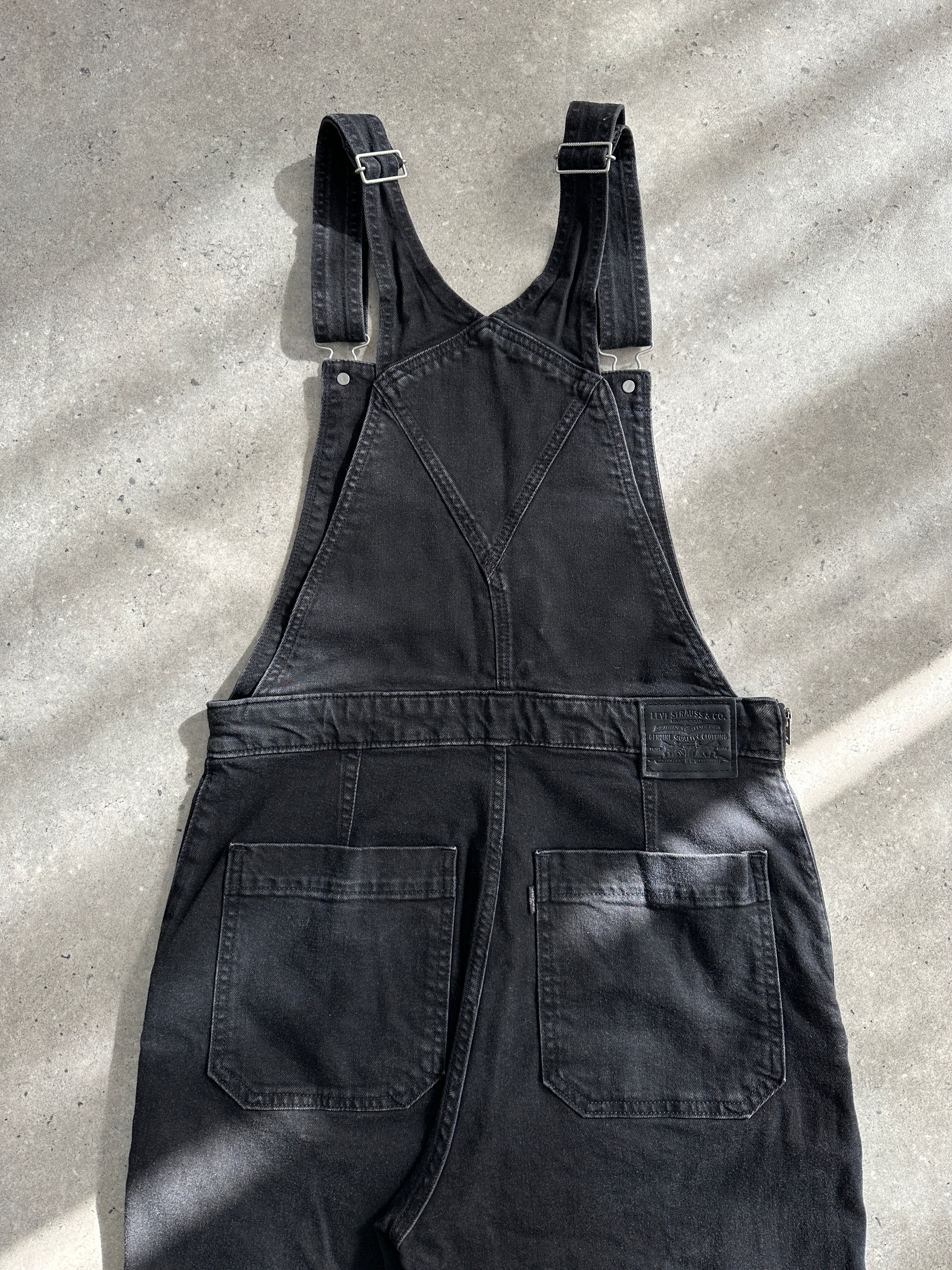 Levi’s Premium Denim Dungarees in size M, featuring classic blue denim, adjustable straps, and front pockets, laid flat.