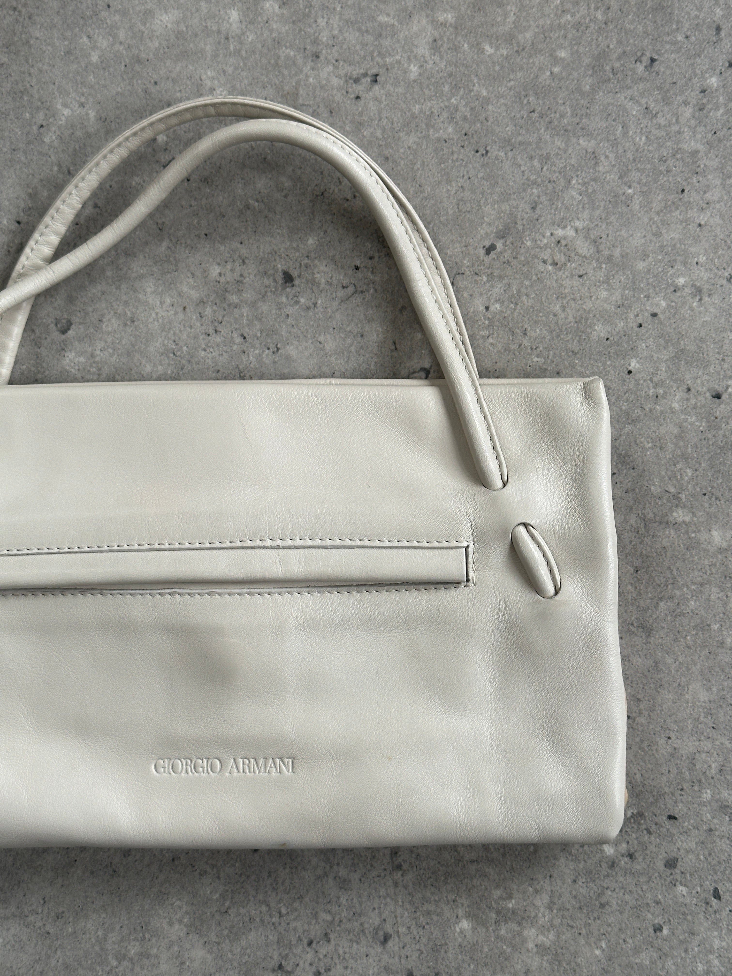 Giorgio Armani Le Collezioni embossed logo handbag with structured shape and textured leather in a classic design.