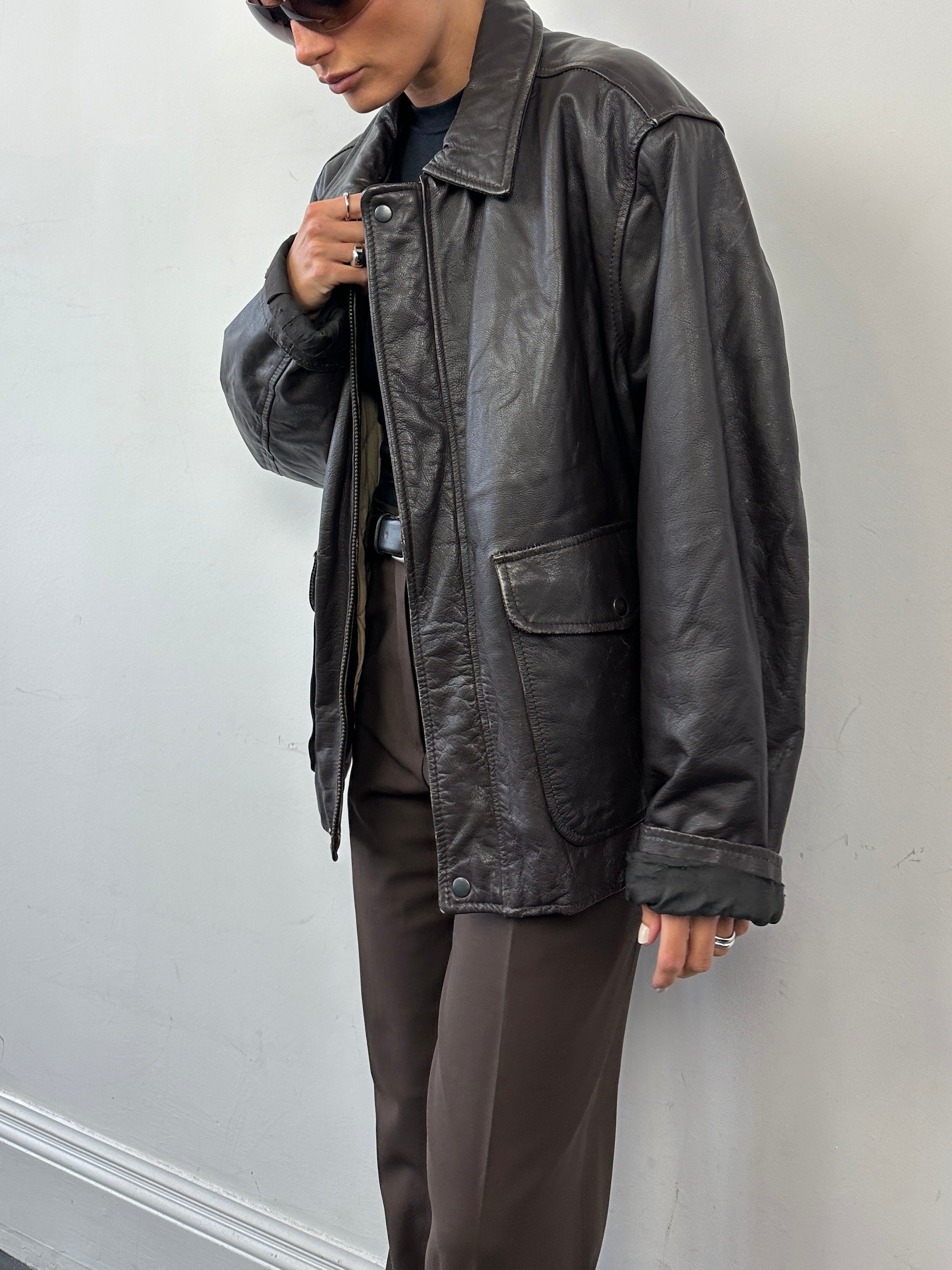 Vintage minimal zip-up leather jacket in XL with clean design and classic collar, displayed on a hanger.
