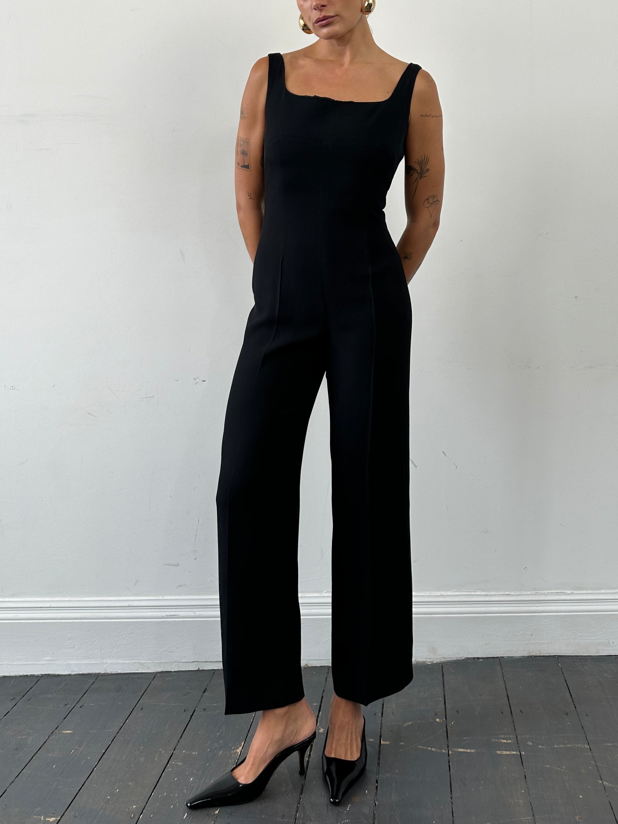 Max Mara square neck jumpsuit in black, featuring a fitted silhouette and sleeveless design, displayed on a hanger.