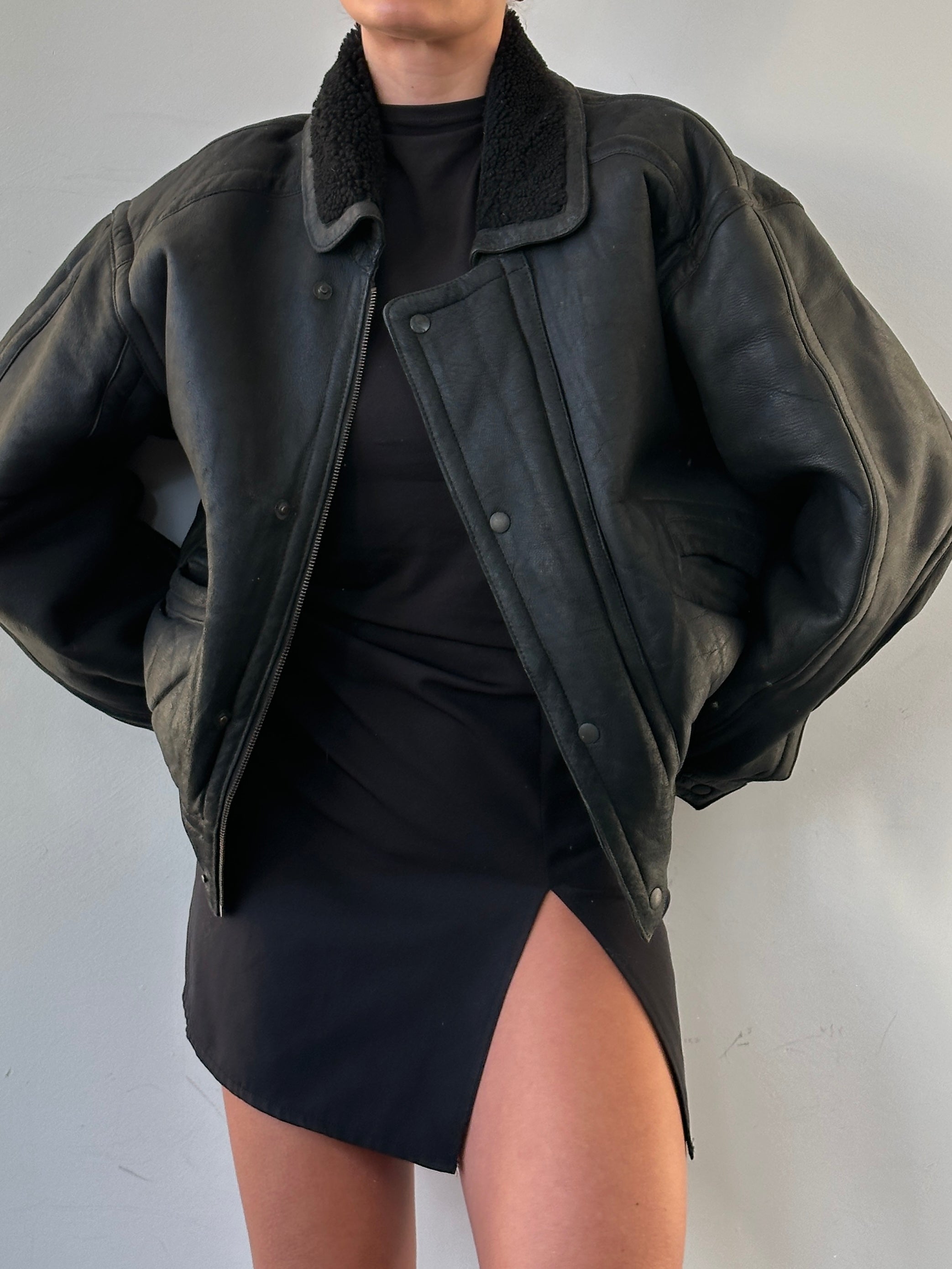 Vintage shearling leather jacket in size M/L with classic collar, front zipper, and textured leather exterior.