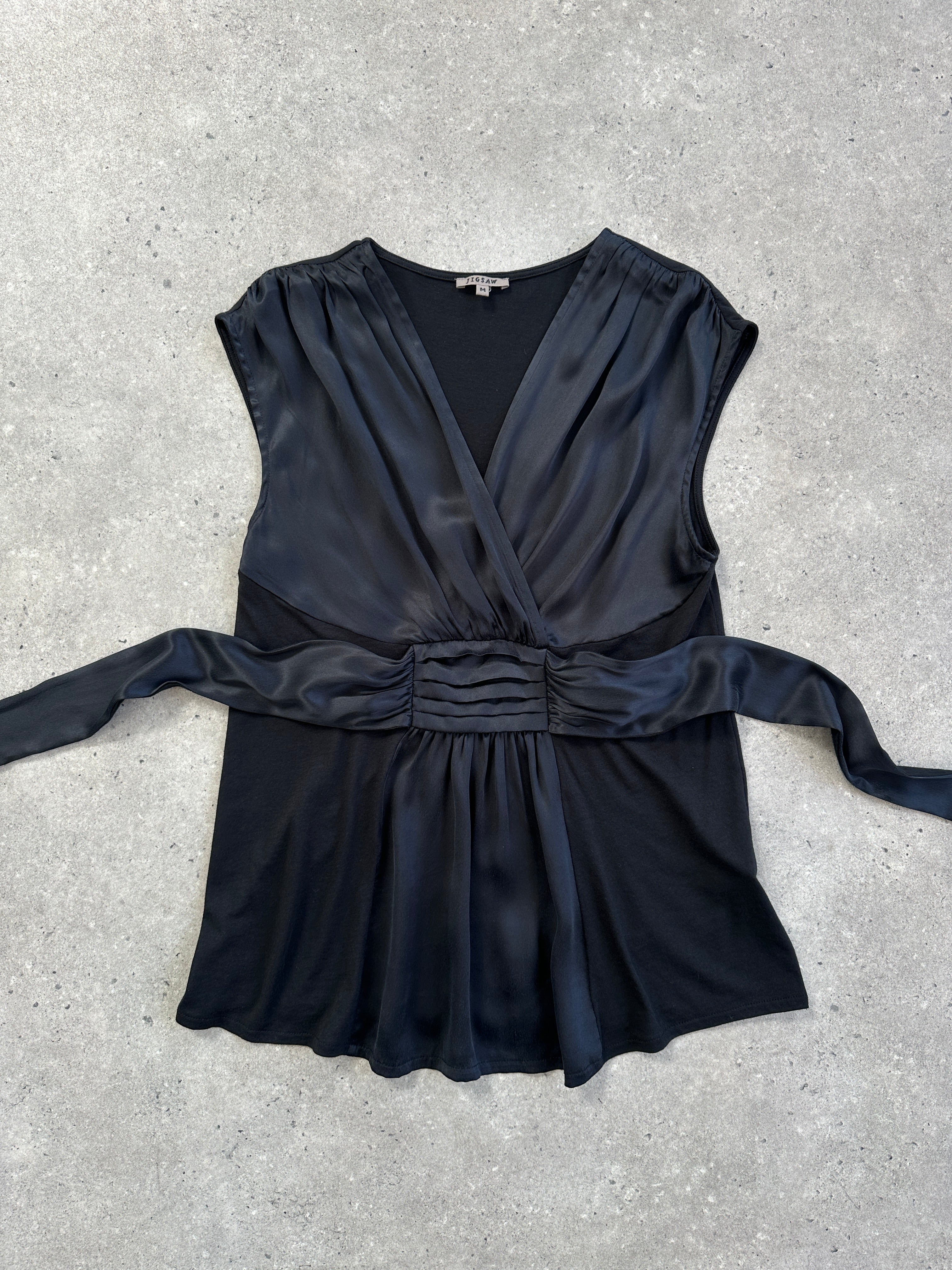 Jigsaw silk tie vest peplum top in size M, featuring a sleek design with a tie detail and peplum style, displayed on a hanger.
