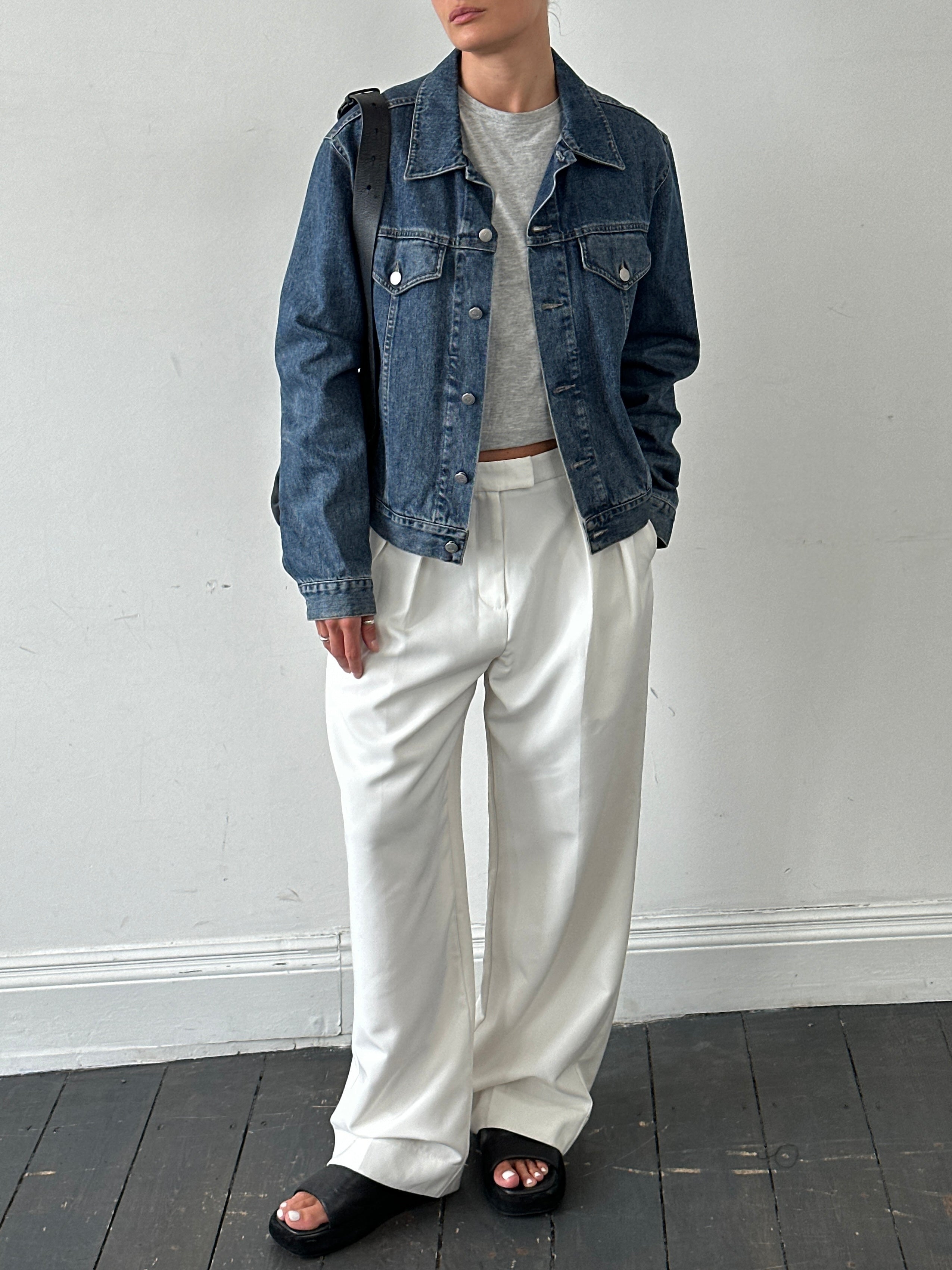 Armani Jeans denim jacket in medium size displayed on a hanger, featuring classic blue denim and button details.