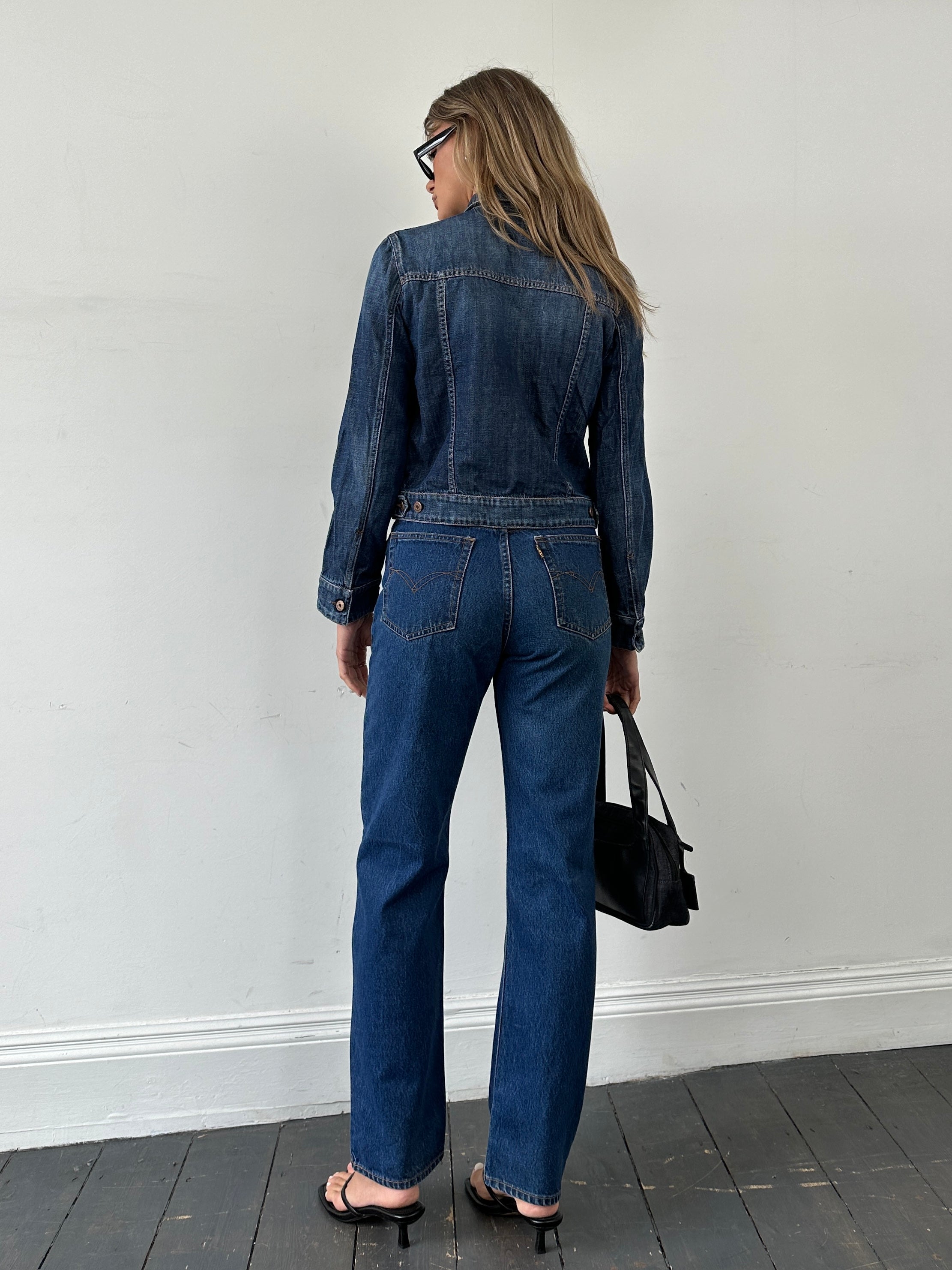 Vintage pure cotton straight leg denim jeans in size W28 displayed on a hanger, showcasing classic blue wash and simple design.