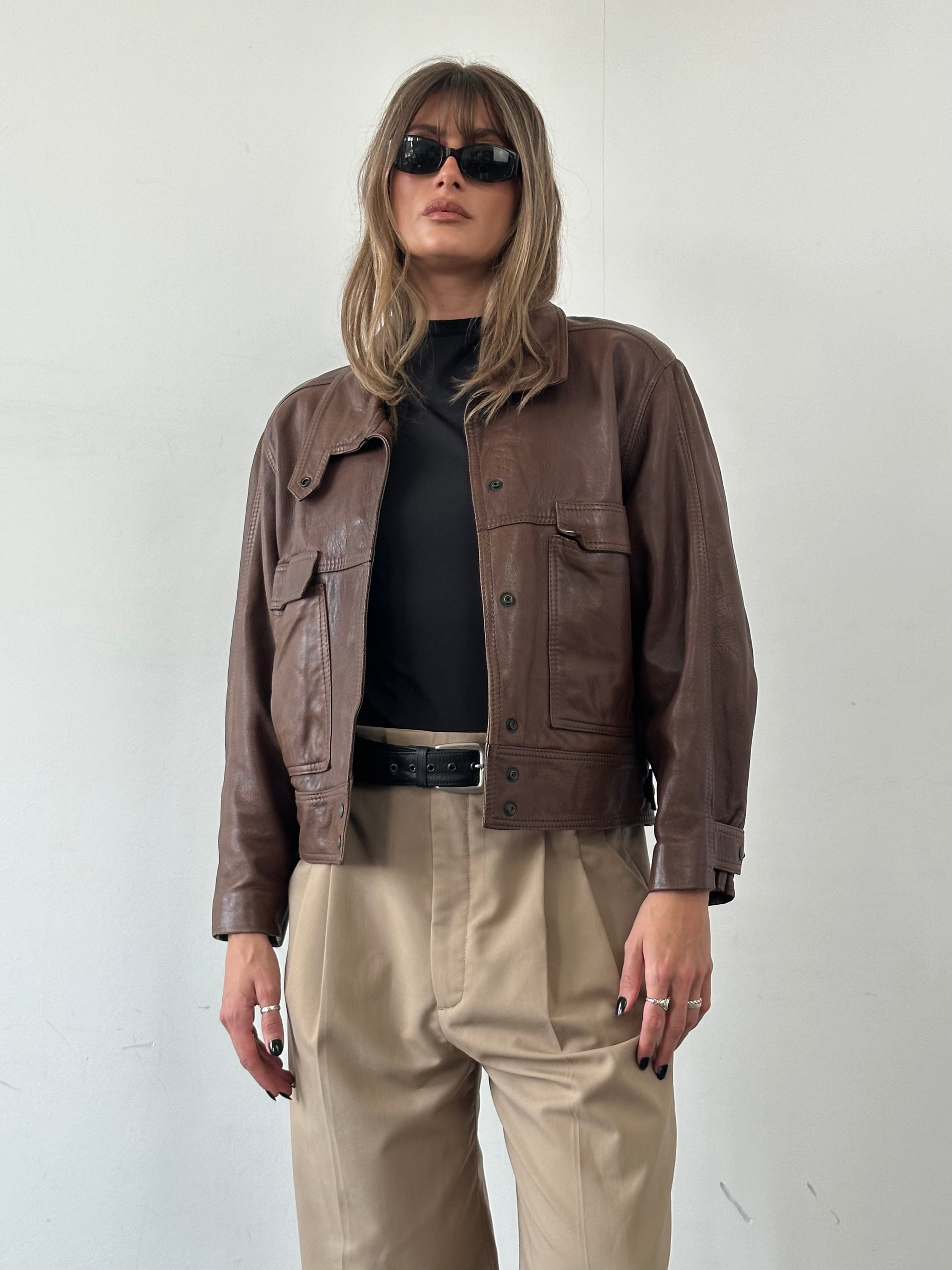 Vintage cropped leather jacket with classic design, styled for a S/M fit, featuring a timeless vintage fashion look.