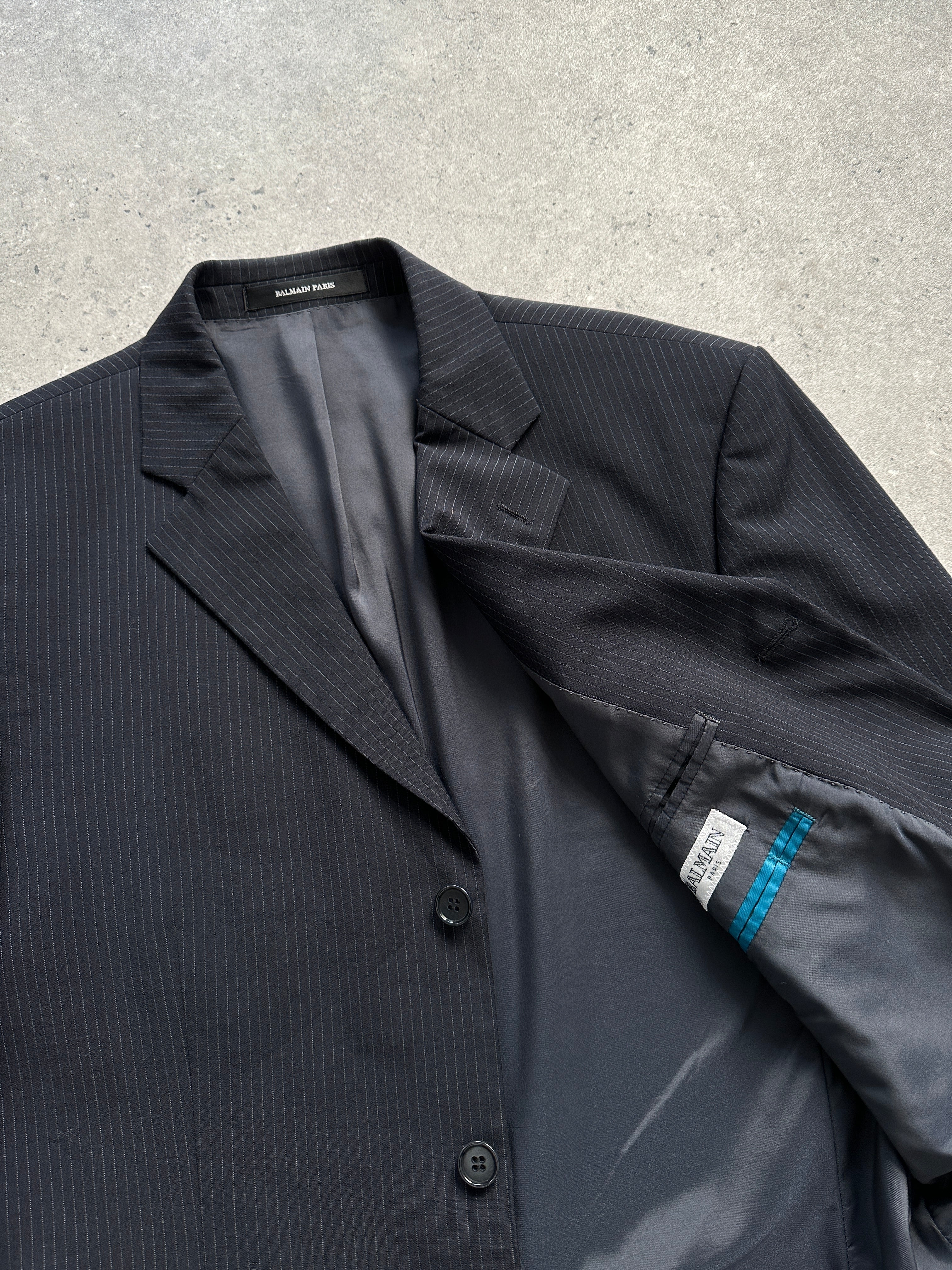Balmain pinstripe wool blazer in size 42R/XL, single-breasted with notch lapel and tailored fit, displayed on a hanger.